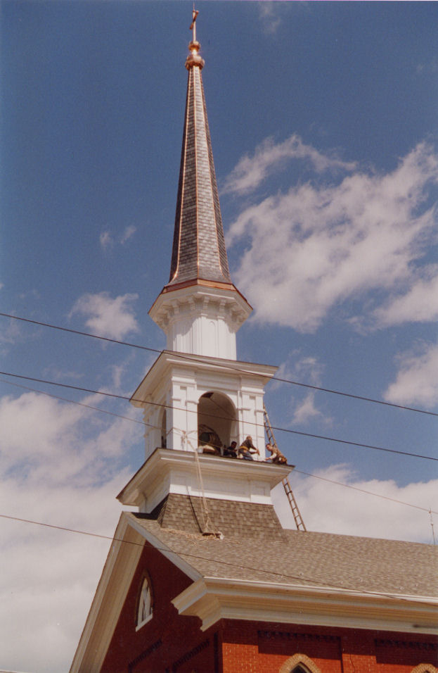 A two cupola steeple with tall, thin spire atop