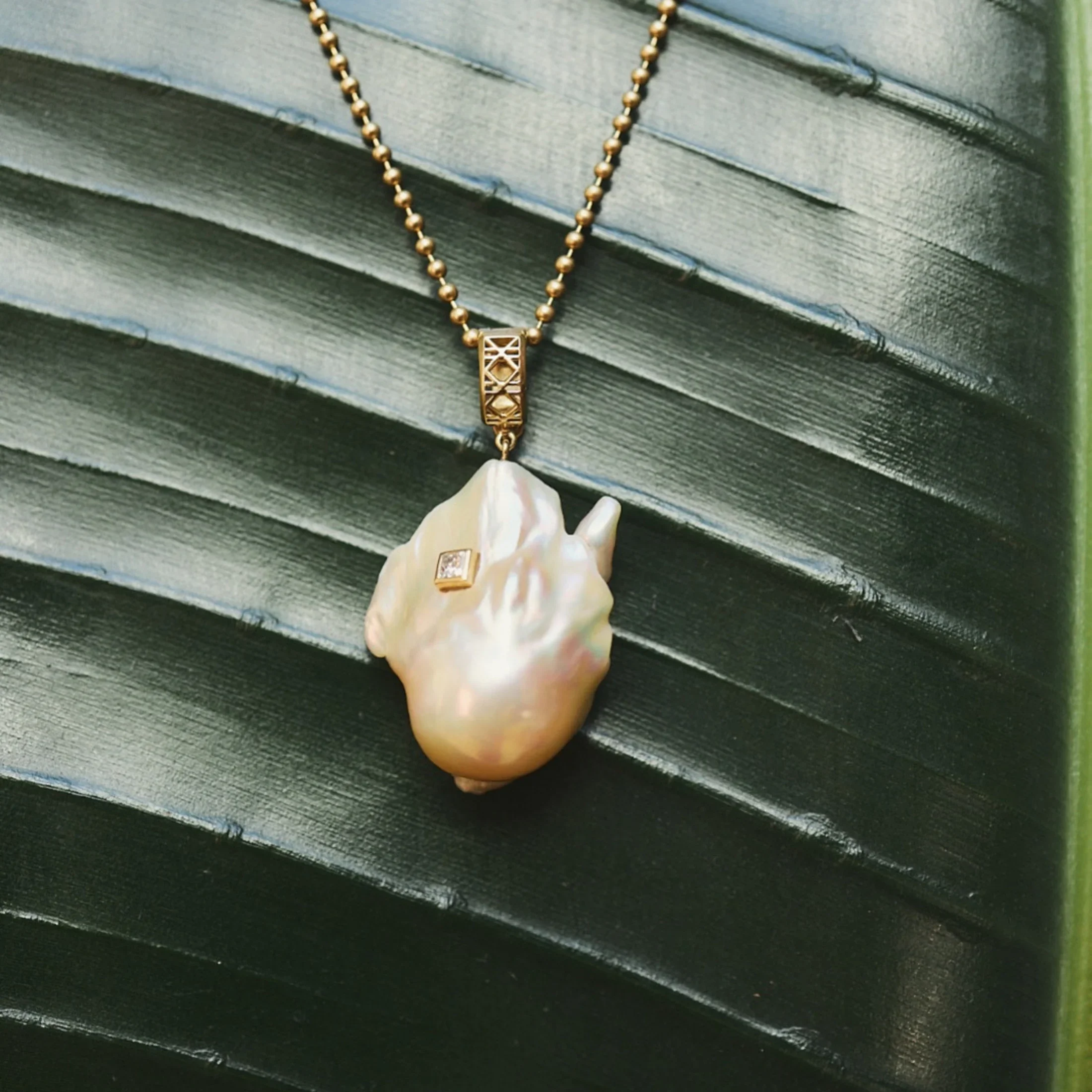 moana-luu-abyss-south-sea-baroque-pearl-amulet-18k-gold-diamond-leaf.webp