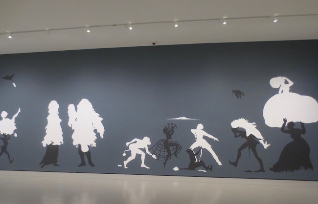 "The Rich Soil Down There" (2002), by Kara Walker. Cut paper and adhesive on painted wall. Museum of Fine Arts, Boston. In 19th-century American homes, small and delicate silhouettes of loved ones and happy domestic scenes decorated the walls. Finding silhouettes, and racial stereotypes, reductions of human beings, Walker transforms this quaint tradition by turning an entire museum wall into a large tableau of racial and sexual violence in the pre-Civil War South.