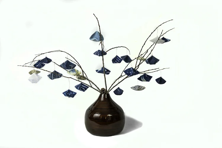 Indigo Tree, I 28”x40” painted silk organza; indigo hand-dyed silk, cotton, linen; design samples; copper wire; stitched by hand; twigs, pine cones; bamboo vase