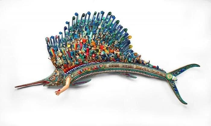 Game Fish ( 1988), by Larry Fuente. fiberglass, black auto-body type epoxy resin, polyurethane resin, plywood, plastic found objects including beads, buttons, poker chips, badminton birdies, ping pong balls, rhinestones, coins, dice, plastic figurines, combs, miniature pinball games. Washington, D.C., Smithsonian American Art Museum, Renwick Gallery. Source: americanart.si.edu/artwork/game-fish-32281/