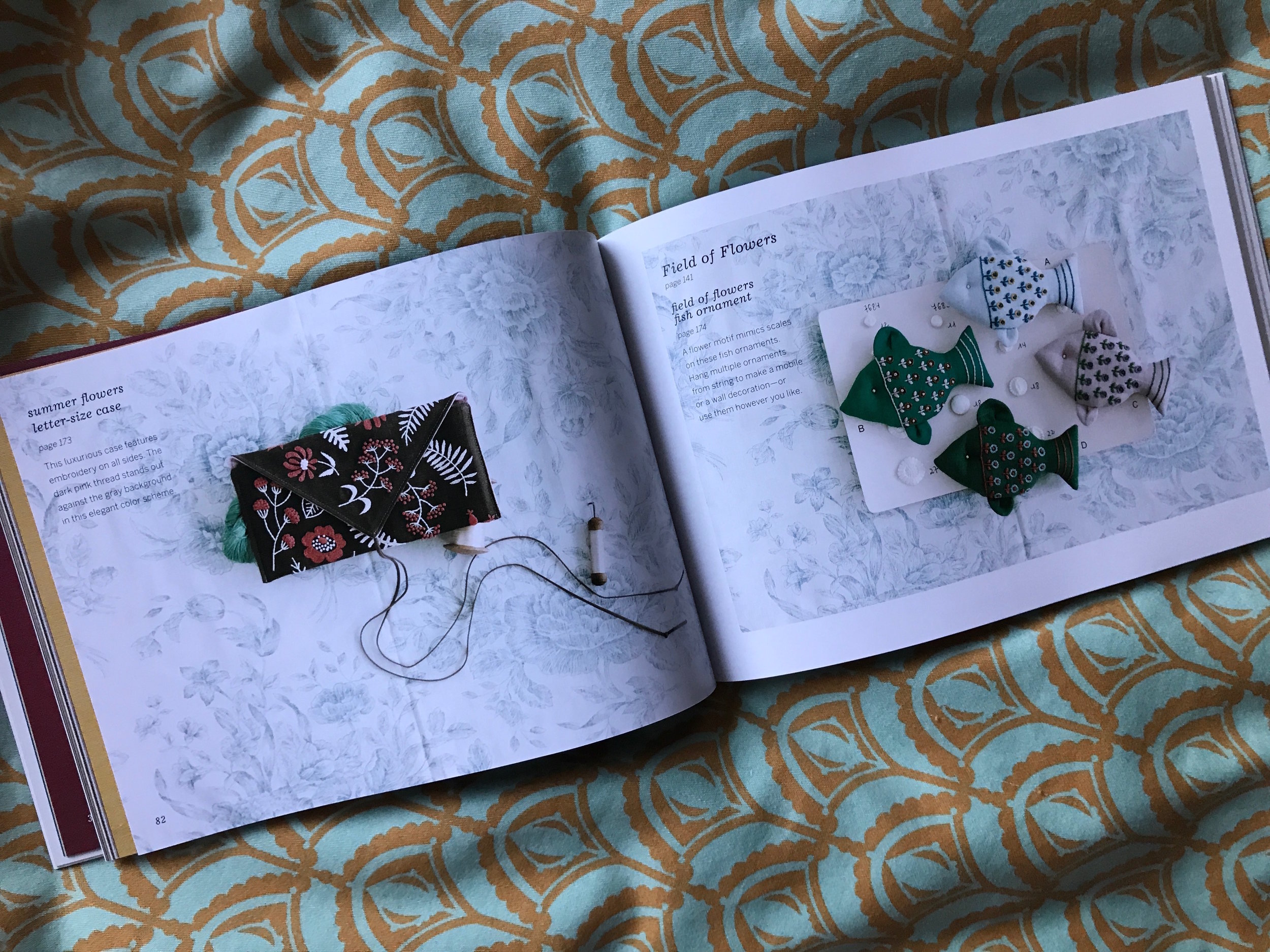 A beautifully embroidered envelope clutch and fish ornaments. 