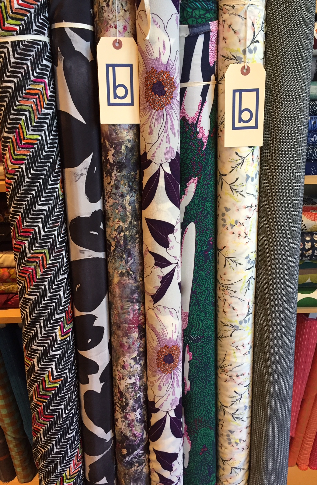 Some really interesting and gorgeous pieces in this here pic! On the far left is a rayon knit gauze that is so lovely and delicate, with a bold colored design. A couple of silks, large floral poly crepe with detail so sharp, three rayons, the third in from the left is an incredible jungle print in navy, kelly, fuchsia and white, striking!