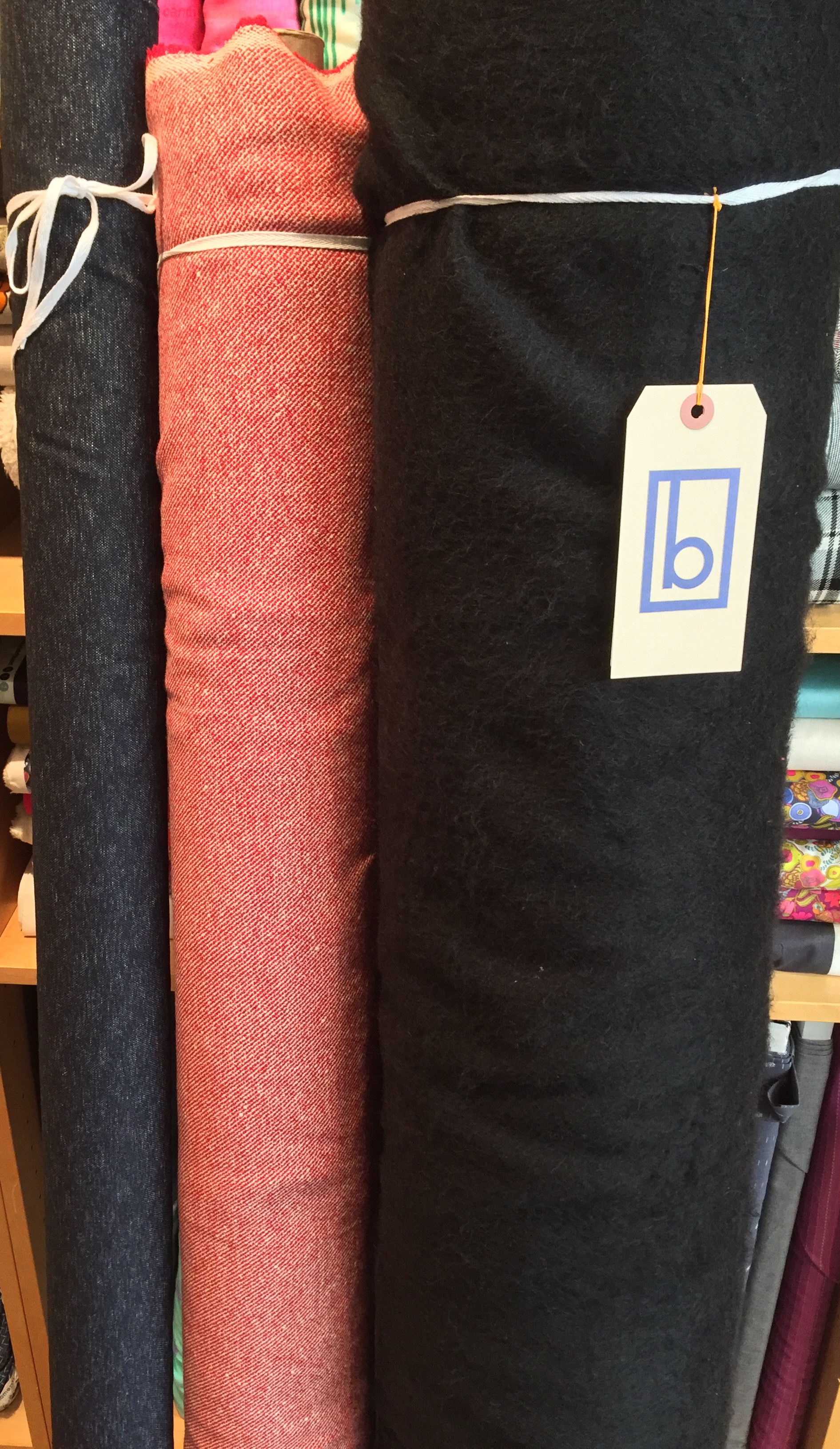 More wool blends: navy wool stretch tweed, red twill, and black acrylic fuzzy blend.