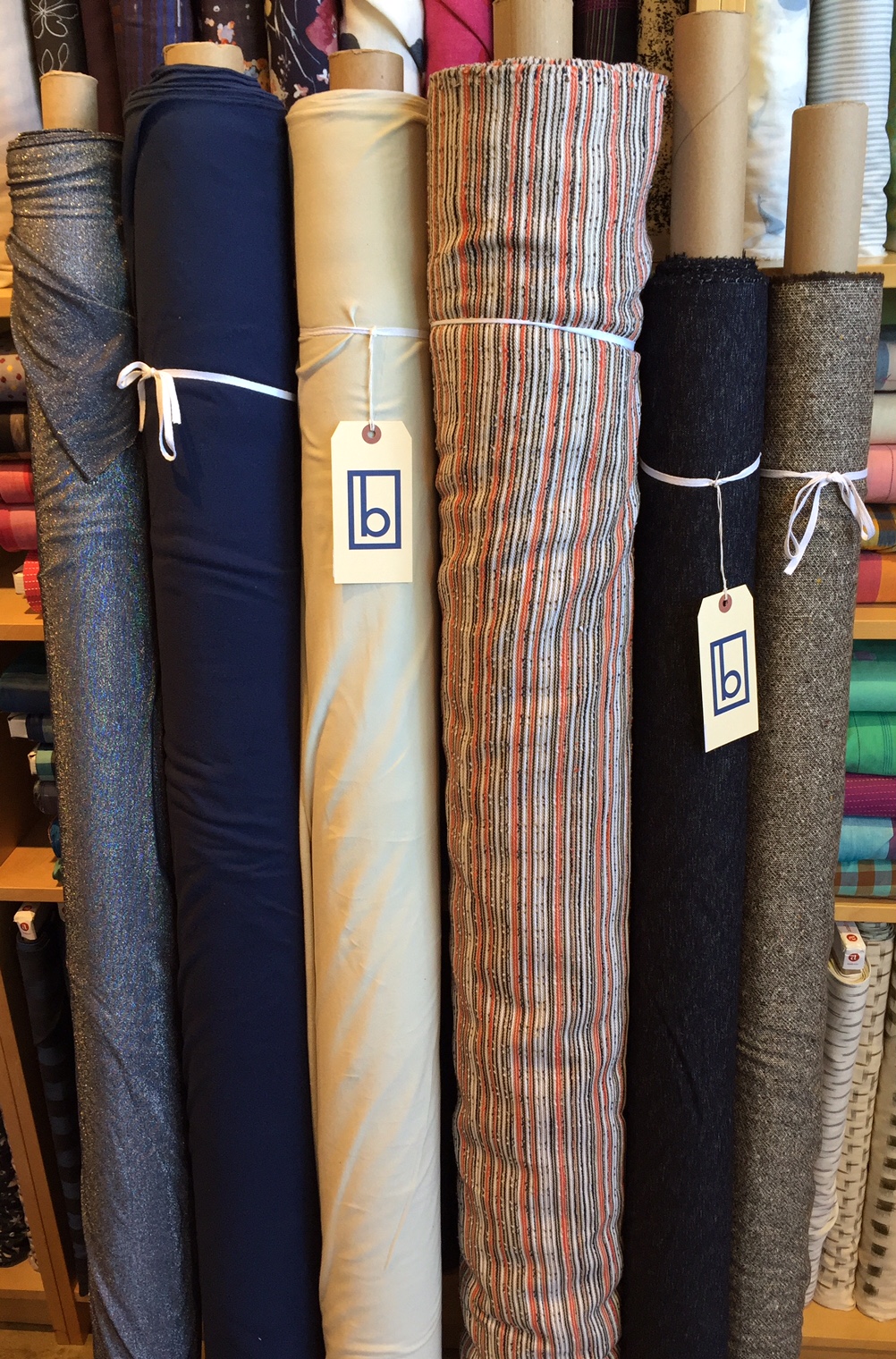 (L to R): Metallic knit, two low loop cotton terry knits with incredible drape and stretch, cotton woven stripe, two wools.