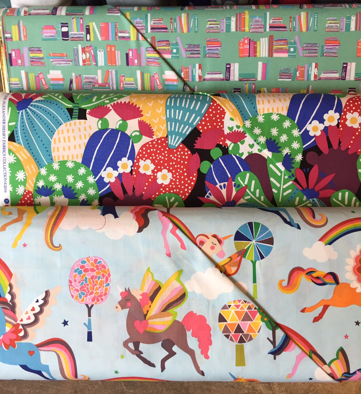 books, colorful cacti and Pegasus with rainbow wings from Alexander Henry