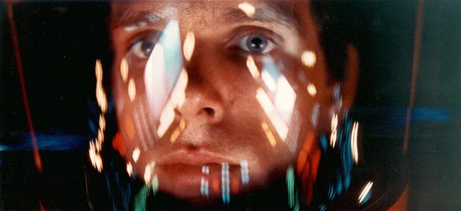 Dave in 2001 A Space Odyssey staring toward camera with lights reflected in his helmet visor
