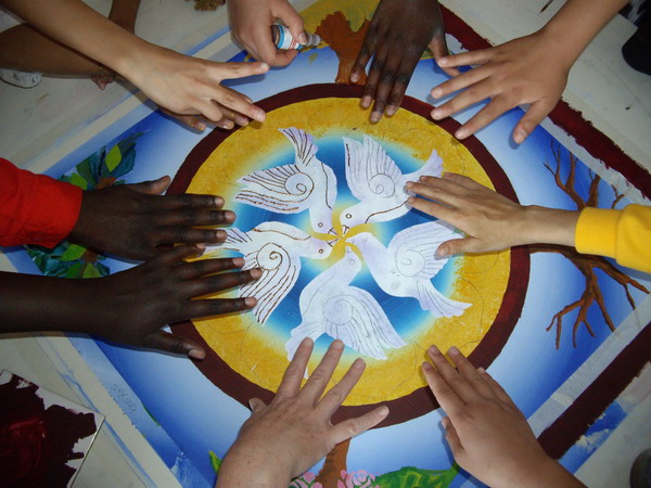 Artist in residence. Children at a primary school create a large mandala for their harmony garden. It reflects a space where there is peace; a safe place to sit and be. This is the center.