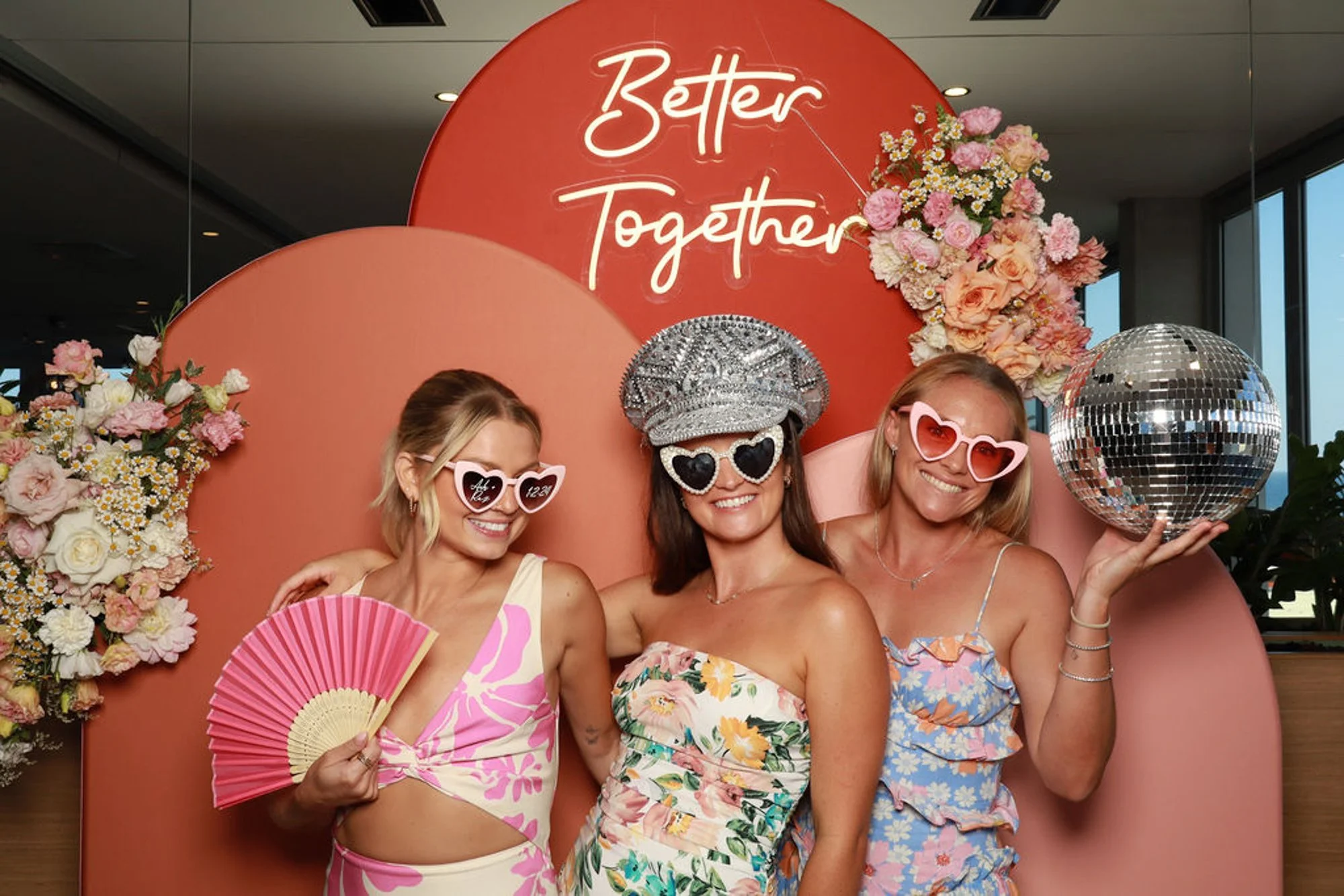 Guests celebrating against the layered sculptural forms of the Sand Dune Arches photo booth backdrop.