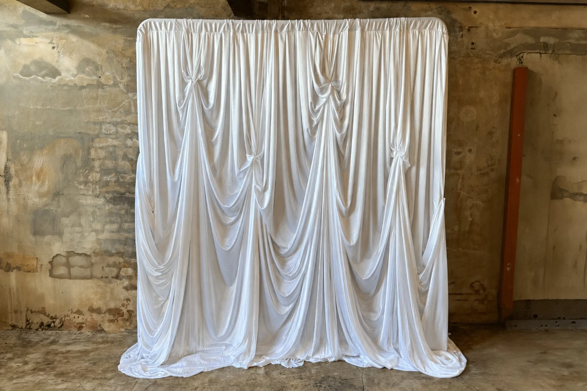 Gathered ivory silk draping with cascading folds creating the Ivory Silk Drape luxe photo booth backdrop.