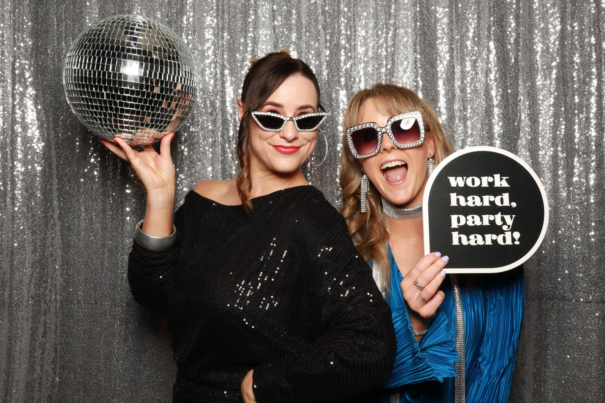 Corporate event guests posing with disco ball and fun props at Photo Corner photo booth.