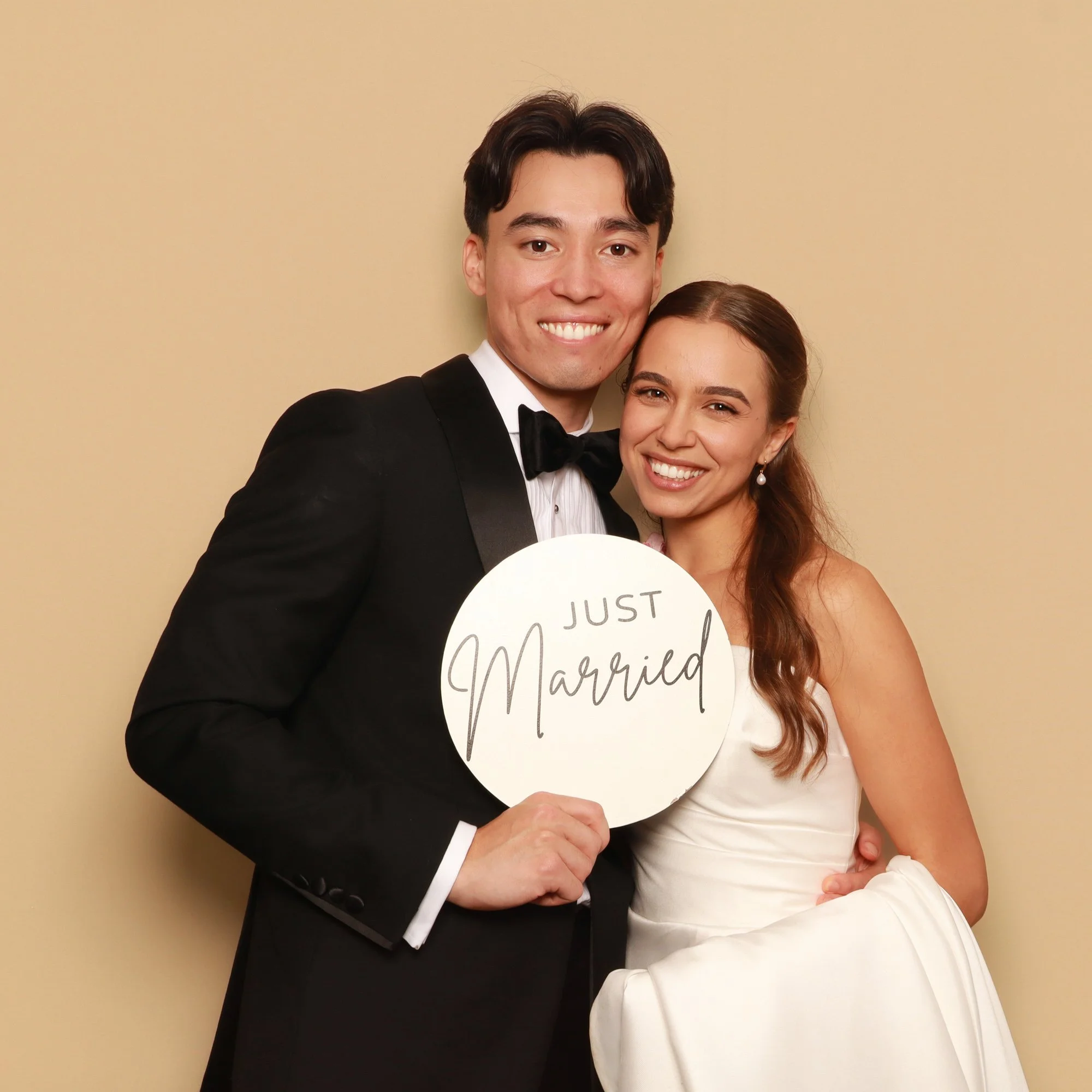 Newlyweds holding a Just Married sign in a Photo Corner wedding photo booth.