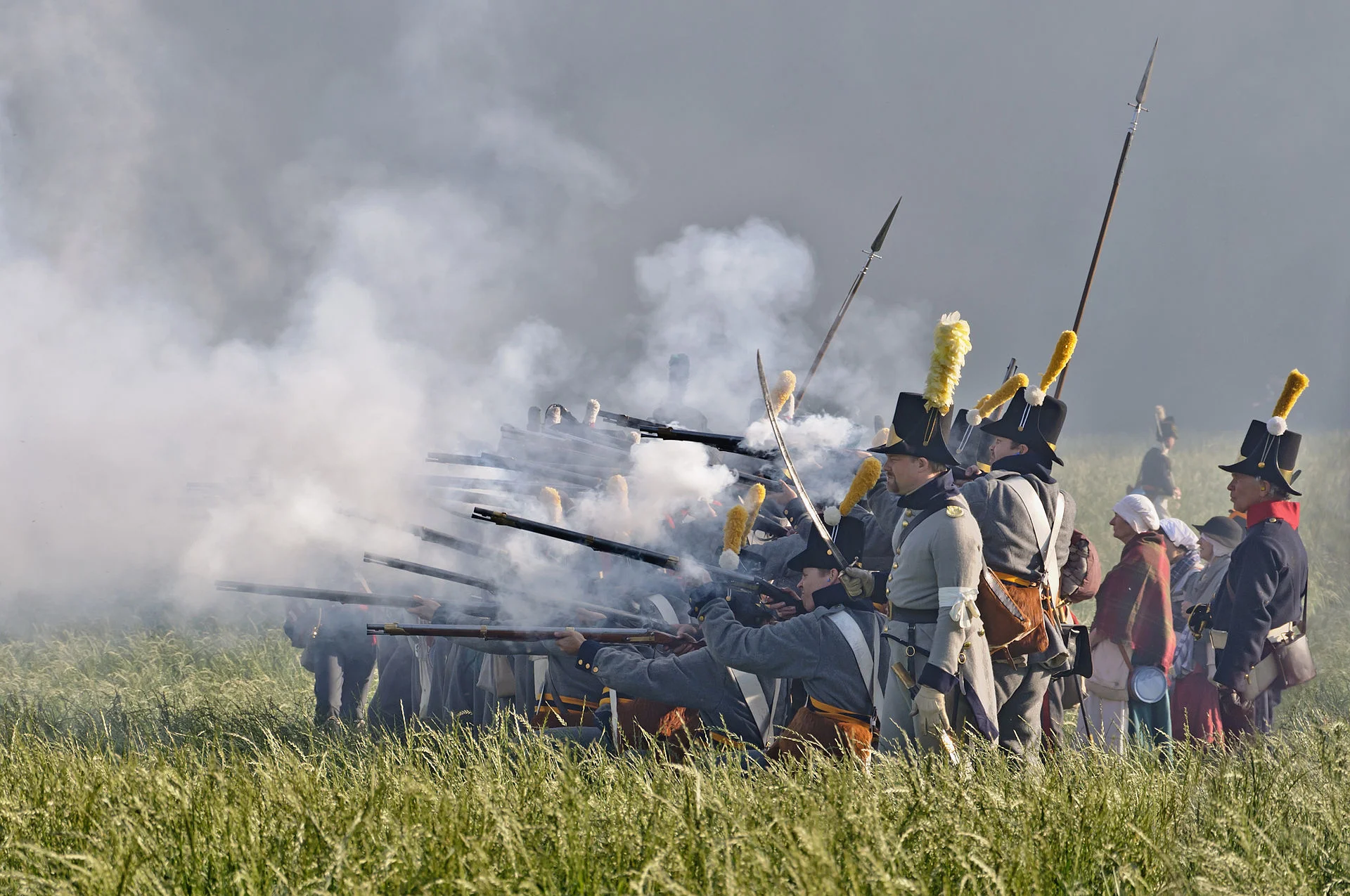 Soldiers in front of the wood of Hougoumont during the reenactment of the battle of Waterloo (1815), June 2011, Waterloo, Belgium, via Wikipedia.