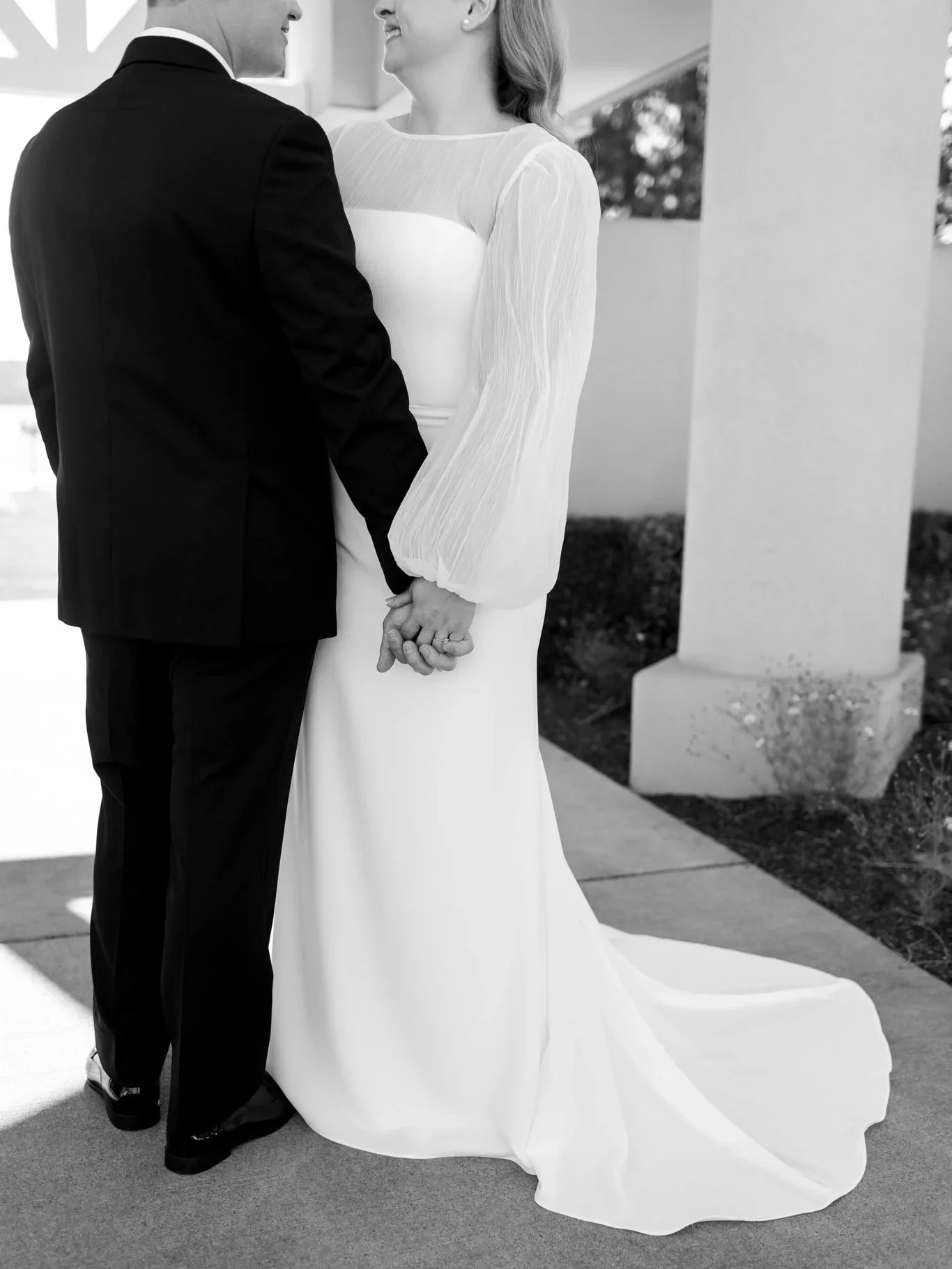 Black and white photo of the bride and groom holding hands during a quiet moment before their ceremony at the Hagadone Event Center in Coeur d’Alene.