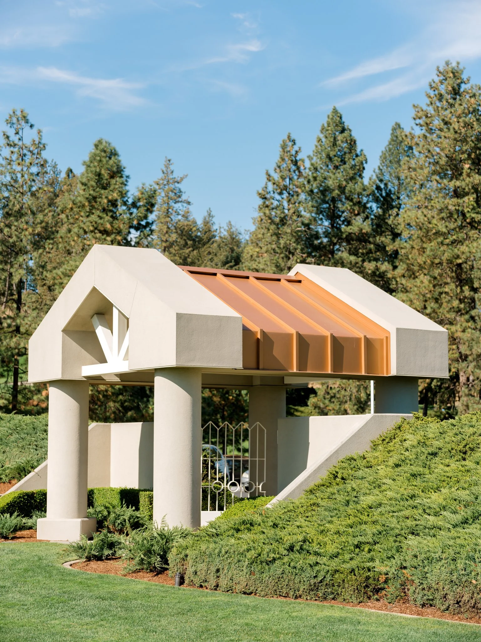Architectural pavilion structure surrounded by evergreens and landscaped greenery at the Hagadone Event Center in Coeur d’Alene.