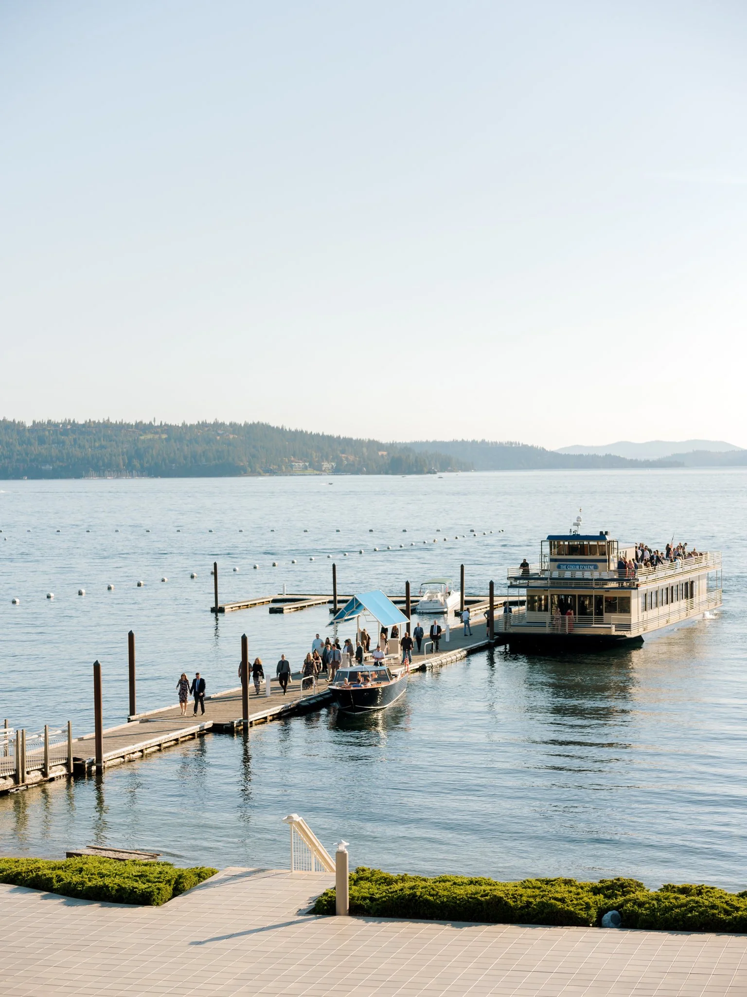 Wedding guests arriving by boat at the dock on Lake Coeur d’Alene near the Hagadone Event Center on a sunny summer afternoon.