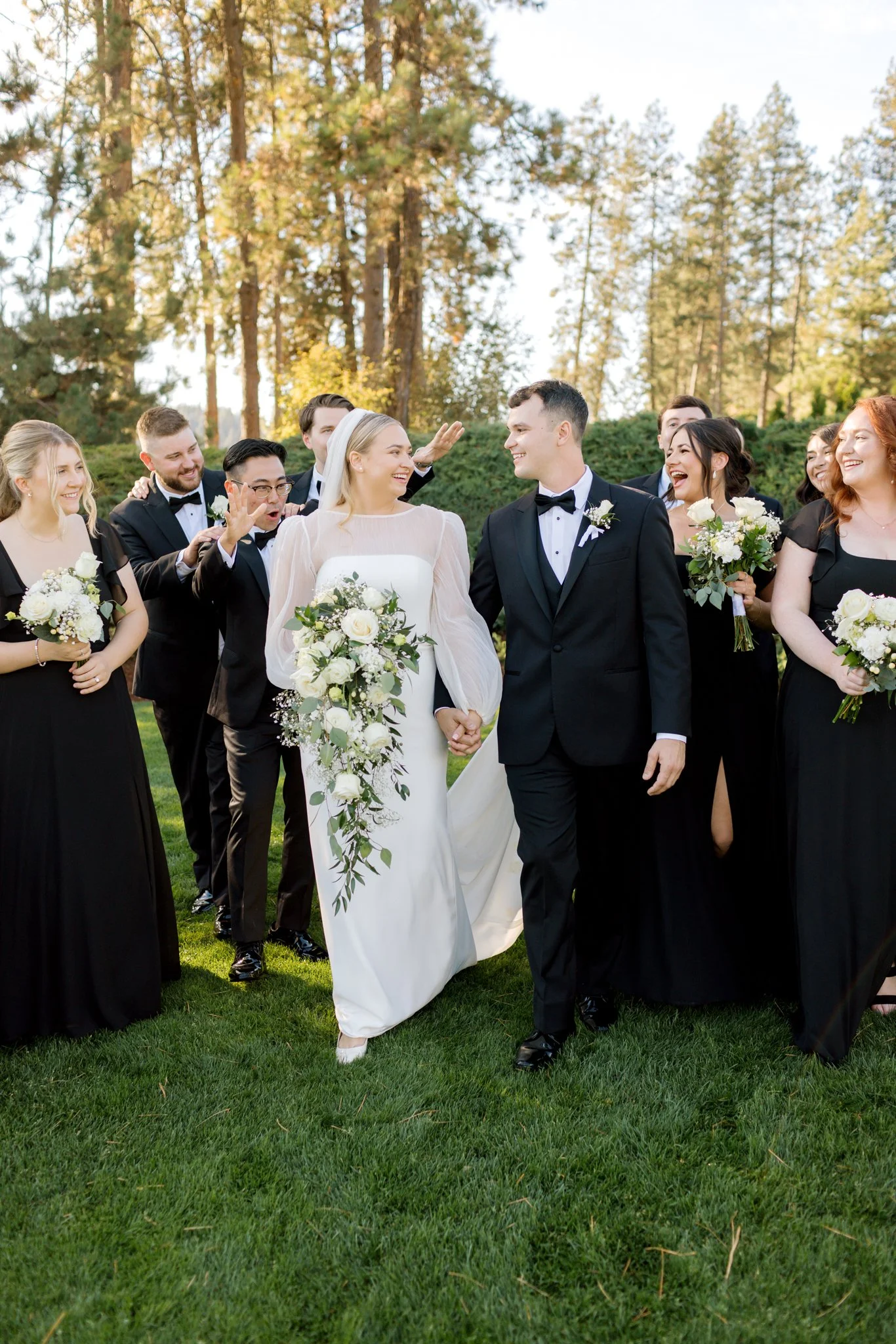 Bride and groom walking with their bridal party during golden hour portraits at the Hagadone Event Center.