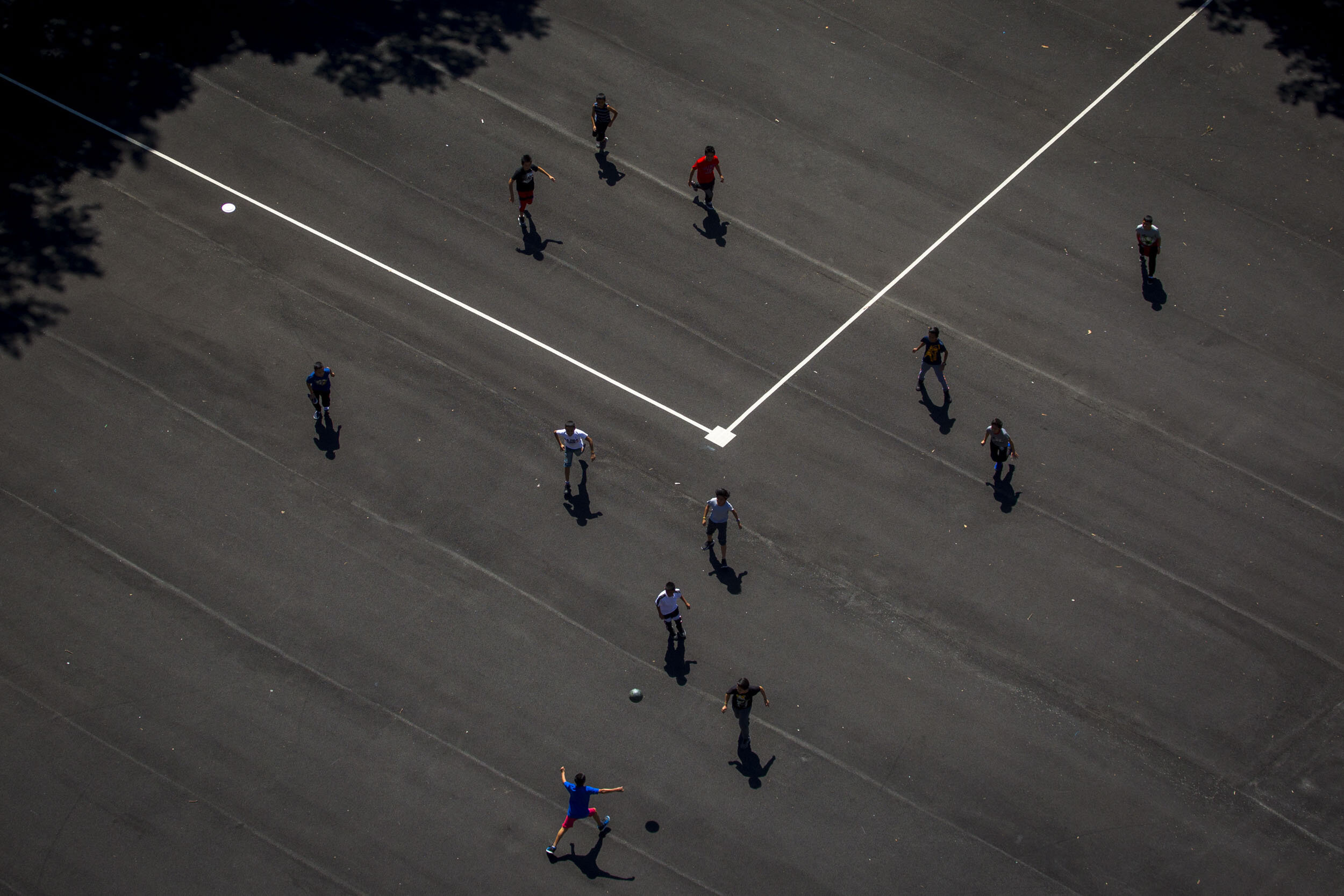  Migrant children separated from their families while crossing the border play together on a NYCHA housing basketball court. New York, NY 