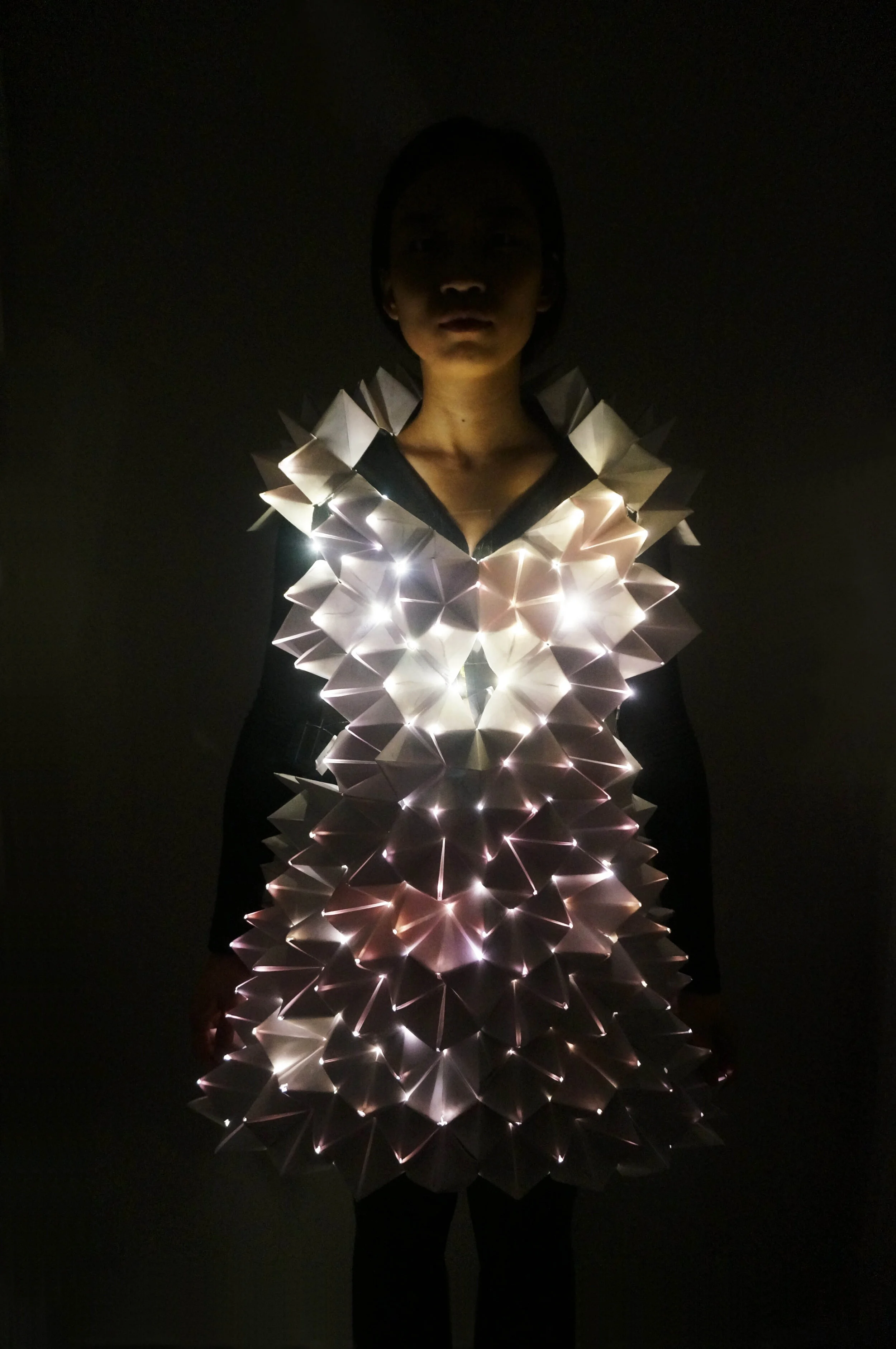 PARA.SENSE by Dan Zhu and Mengning Zhao. This extra-somatic skin has sensors at the tip of the pyramids to detect level of light and will illuminate to make the individual visible if there is not enough to light in the environment. Photo by Austin Yu.