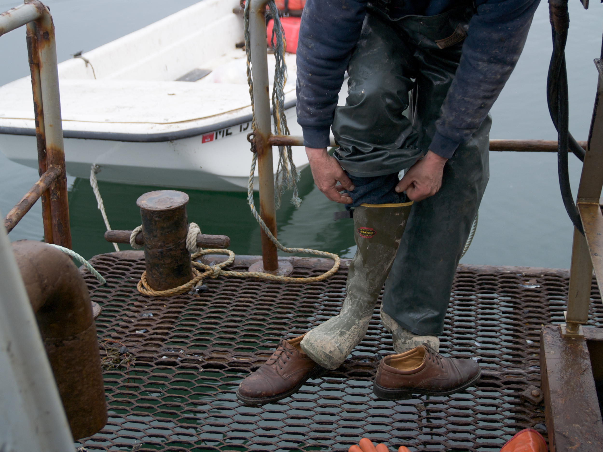 (04/04/09)&nbsp;Cater Newell pulls on a pair of boots. Rubber overalls and rubber boots are needed before getting to work on the barge. The job is a messy one and the crew have have to be prepared to work in all kinds of weather. In rough weather, w