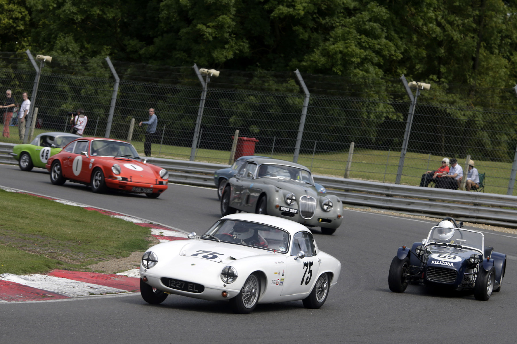 Robin Ellis makes good his escape whilst Brian Arculus, almost hidden, is held off by the Paul De Havilland Jaguar XK150. Photo - Gary Hawkins