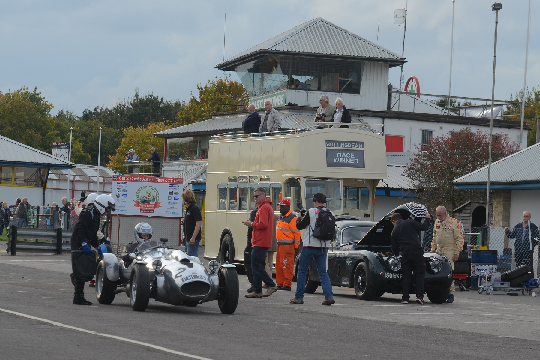 Race sponsor, Peter Campbell (of Spencer- Lane Jones) stands by his Wingfield Bristol Special which has just been taken over by Andrew Mitchell. To the right, the sad sight of the raised bonnet of the XK150 presages the retirement of Claire Keith-Lucas from the race. In the background the wonderful old Bristol open topper used to take the winners on their victory lap. Photo - Ollie Read