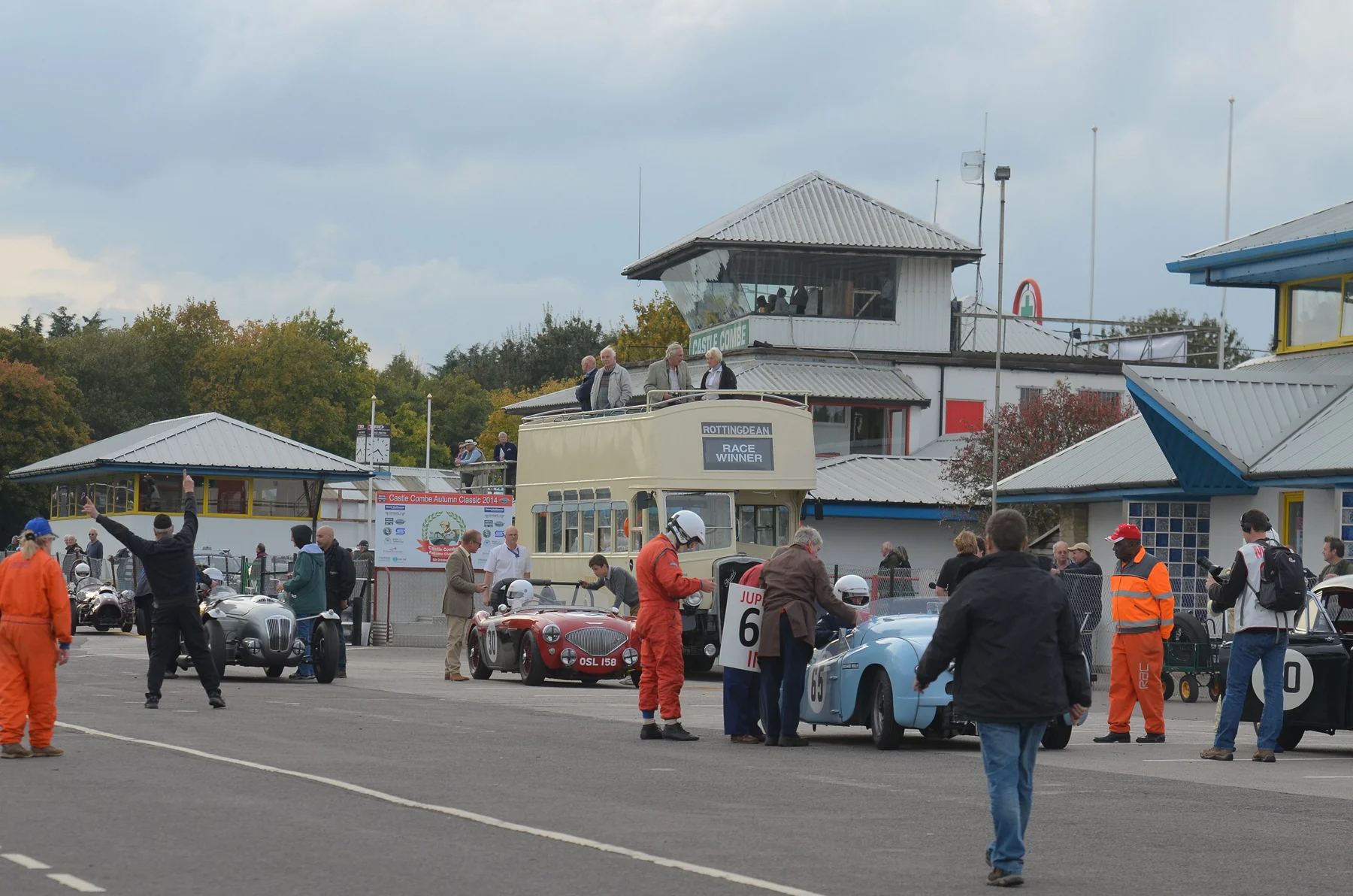 Always great to see the Jowett Jupiter out - Richard Gane and John Arnold change places. Behind, Keith Jenkins, driving the Austin Healey solo this time, waits patiently for his timekeeper to complete countdown, as does Ned Spieker In the Frazer Nash High Speed Model. To the left, much waving of arms heralds the arrival of John Ure in the Cooper Bristol. Photo - Ollie Read