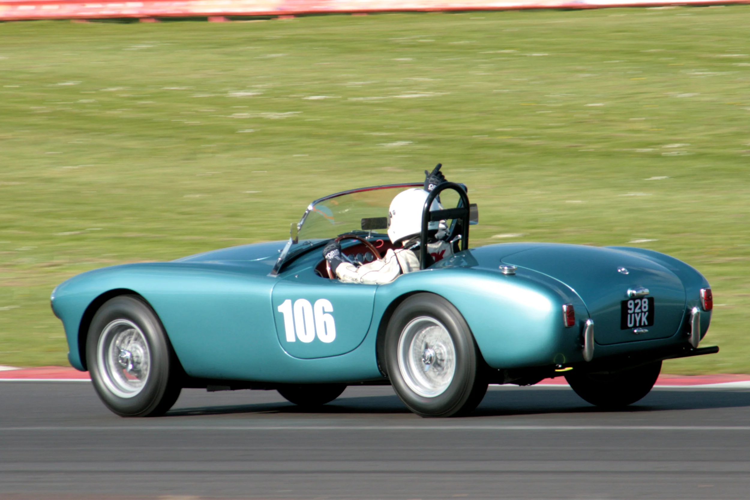 David Cottingham running at unabated speed through Woodcote indicates his intention to take the mandatory 45 sec pit stop on his way to 28th in the Ac Ace Bristol Photo - John Turner 