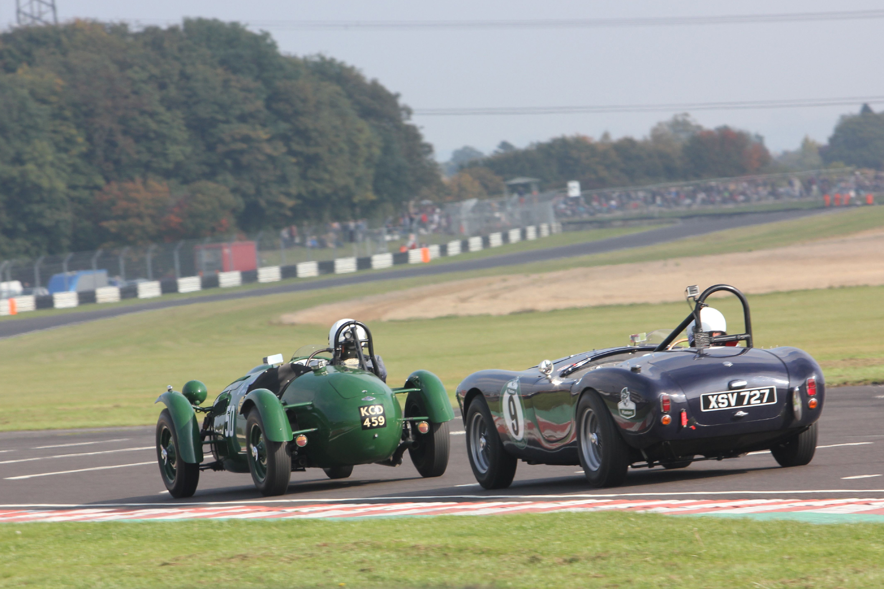 Martin Hunt (Frazer Nash Le Mans Replica) and Ted Murray (AC Ace), lying at this stage 8th and 9th head down the pit straight towards Folly which appears a much more accentuated corner from this angle than it does from most spectator viewpoints and is probably the fastest part of the circuit. The track section above the drivers heads is called appropriately Avon Rise followed by the gentle left hander into the difficult right hander, called Quarry. Photo- Pat Arculus, Tripos Media 