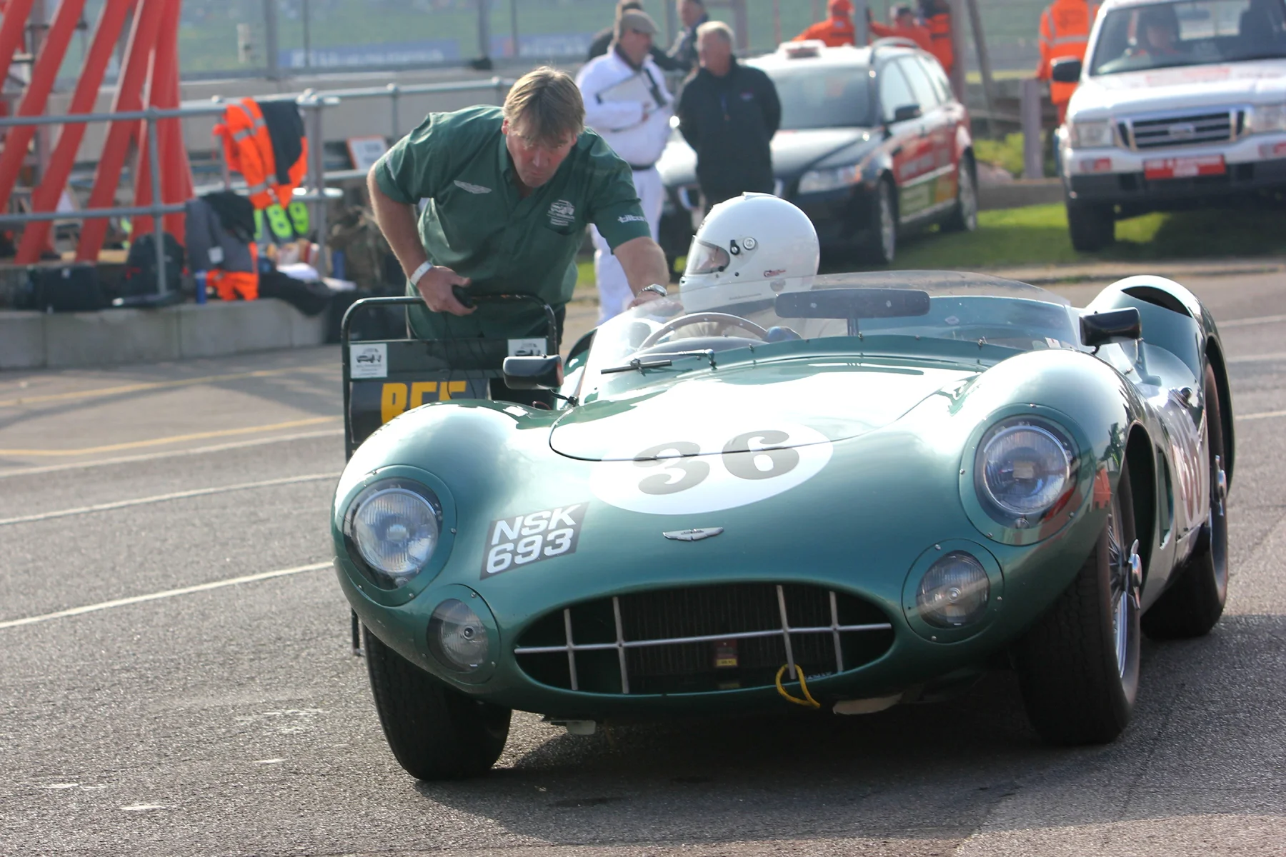 Chris Woodgate leans in to talk to Adrian Beecroft in the Aston Martin DBR1/300, a model which I must confess is my all time favourite sports racing car. I'm sure that in view of subsequent events Adrian probably feels that it would have been good if his race had ended here. Photo - Pat Arculus, Tripos Media