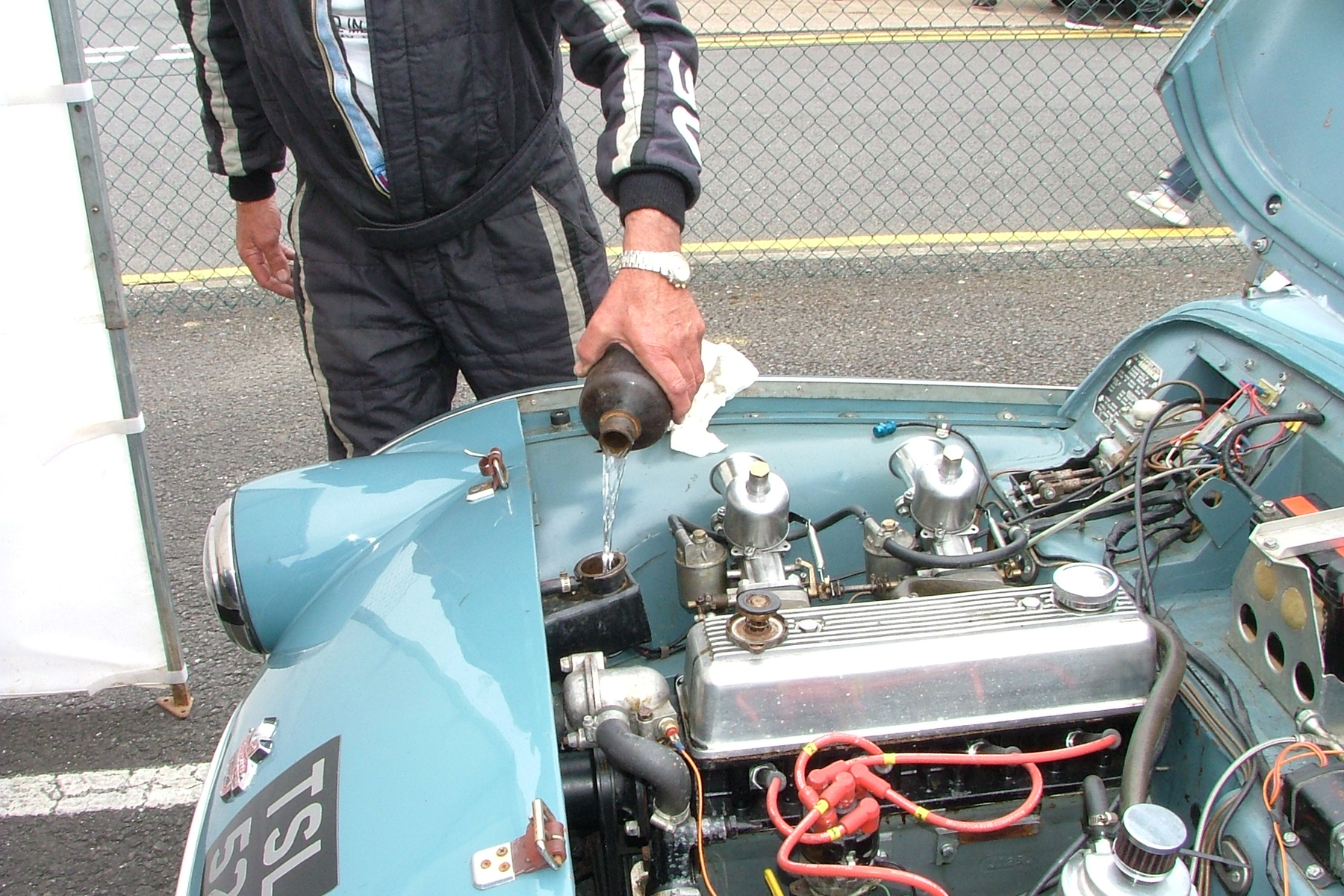 Paul Ziller tops up the header tank on the TR2. It allowed him to complete 4 laps before retiring Photo - John Turner