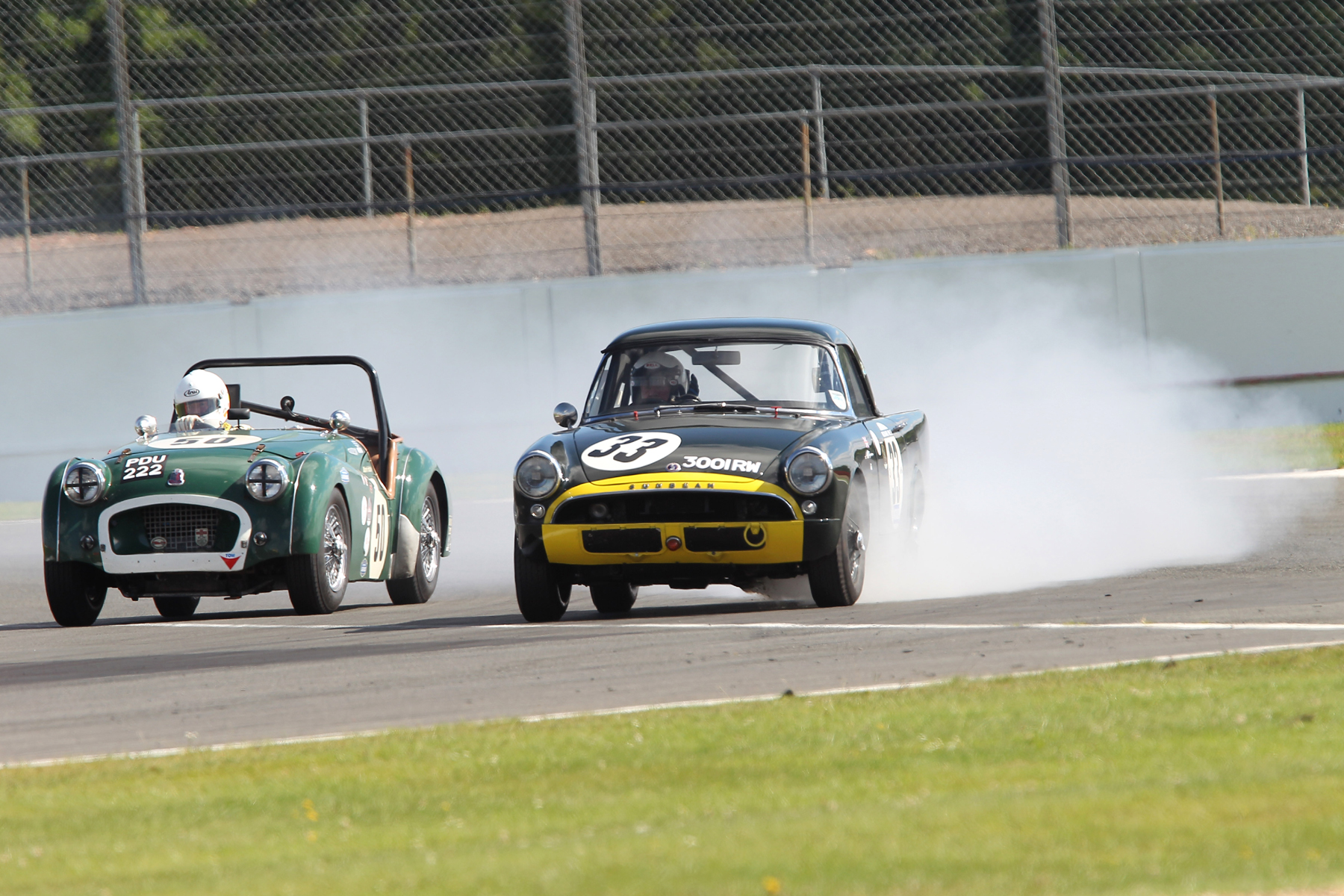 A burst oil pressure gauge pipe brought the Sunbeam Alpine Le Mans practice to a rapid halt and some interesting moments for fellow competitors. Mark Hoble on the inside qualified his TR2, 15th. Photo - Mick Walker 