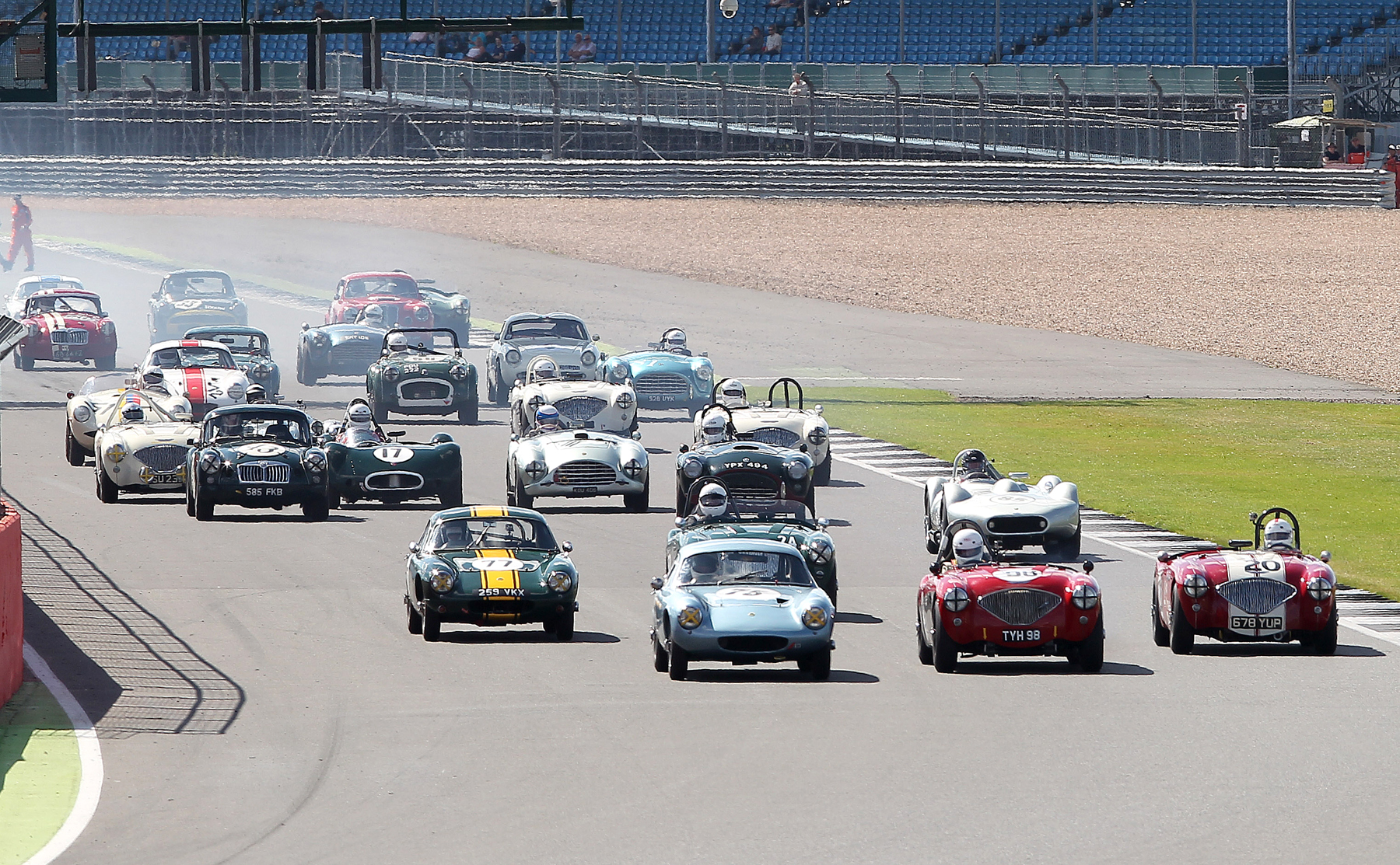 Nick Matthews (Austin Healey 100) makes a great start from the second row to make it three abreast heading into Copse, with Mike Freeman (Elite No 77) and Jim Campbell (Austin Healey 100) in close attendance. Photo - Mick Walker