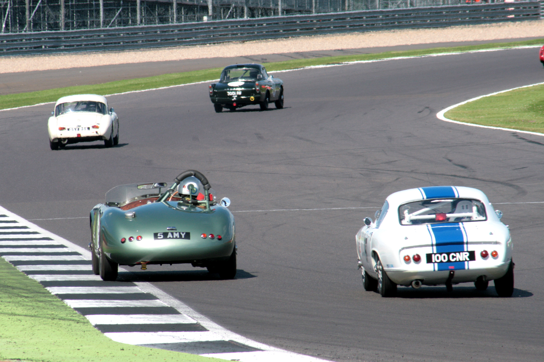 Towards the back, Keith Hampson (Sunbeam Alpine Le Mans) making good forward progress from his enforced low starting position leads Simon Gurney (MGA), Chris Guest (RGS Atalanta) and Nick Atkins ( Lotus Elite) heading through Woodcote. Photo - John Turner