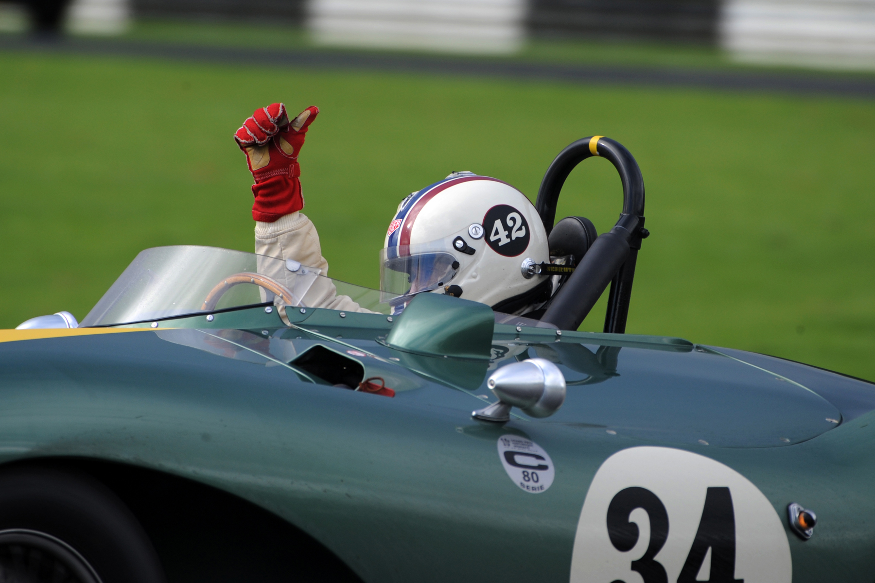Steve Boultbee -Brooks chalking up another victory at Castle Combe gives the thumbs up to spectators and marshals on his slowing down lap. Photo - Jeff Bloxham