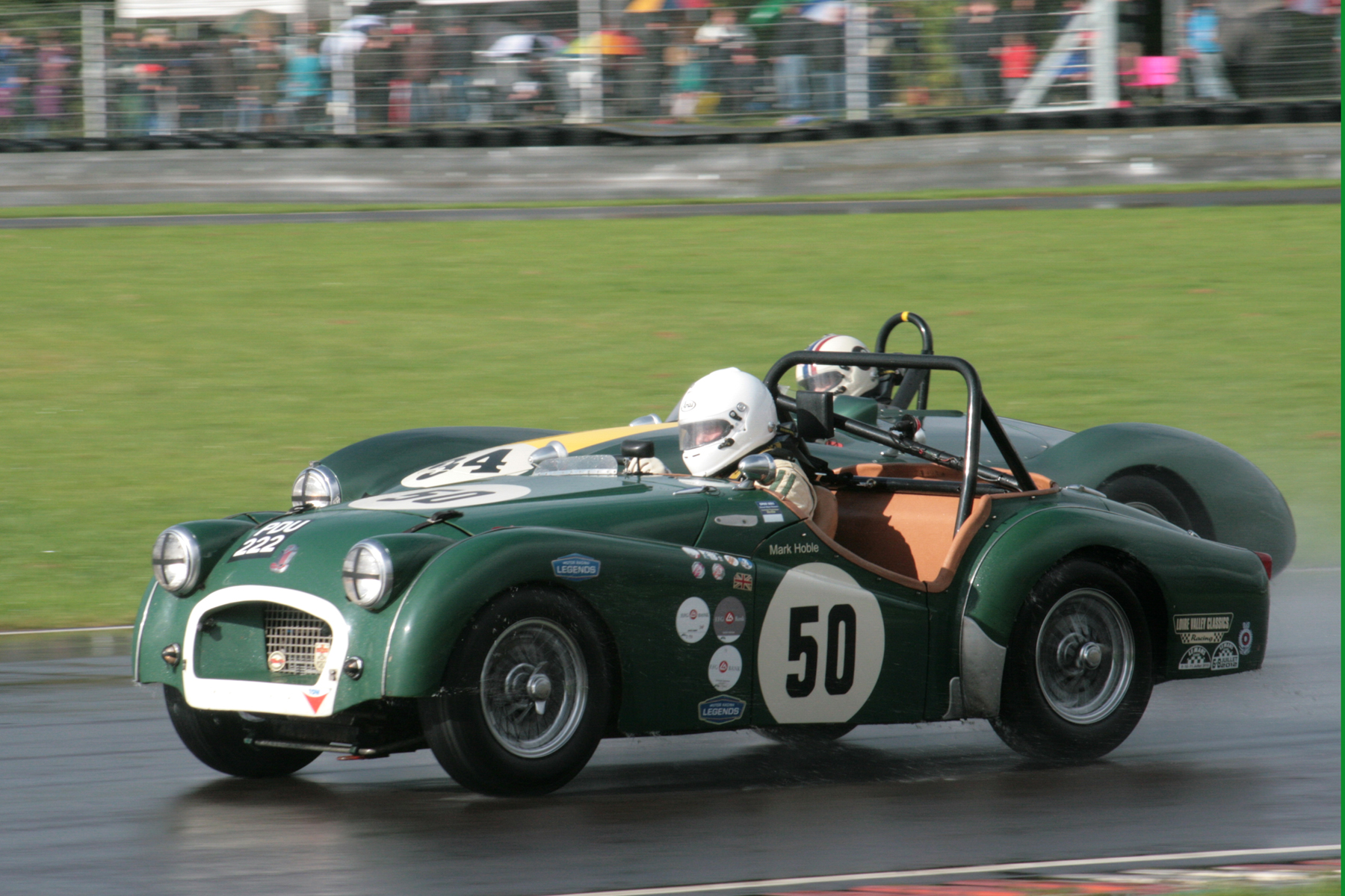 Mark Hoble in his TR2 being lapped by the winning Aston, but Mark won his race long battle with Paul Ziller in the other TR2 by just 2.5 seconds after 30 minutes of racing, winning his class in the process. Photo - John Turner