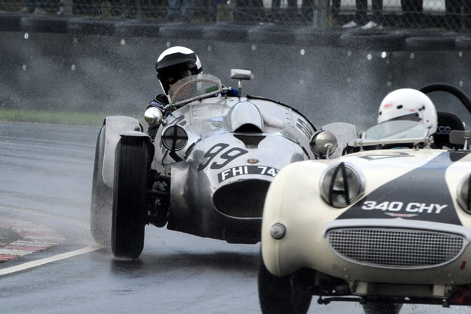 Peter Campbell, his Wingfield Bristol Special surrounded in spray, peers ahead and around Neil Cameron's Frogeye Sprite. A great shot from Jeff Bloxham