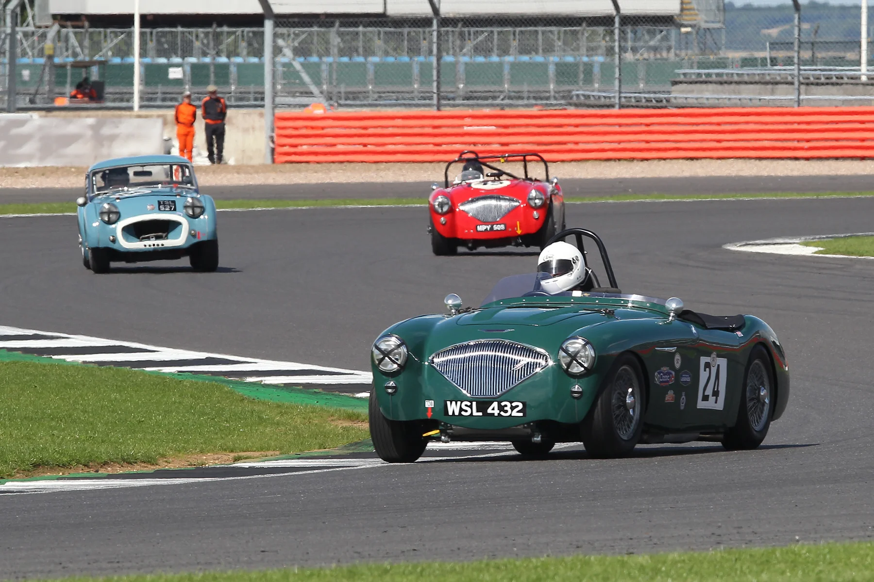 Jim Campbell heads through Luffield as Paul Ziller and Paul Mortimer exit Brooklands. They were lying 4th, 5th & 6th at the time. Photo - Mick Walker