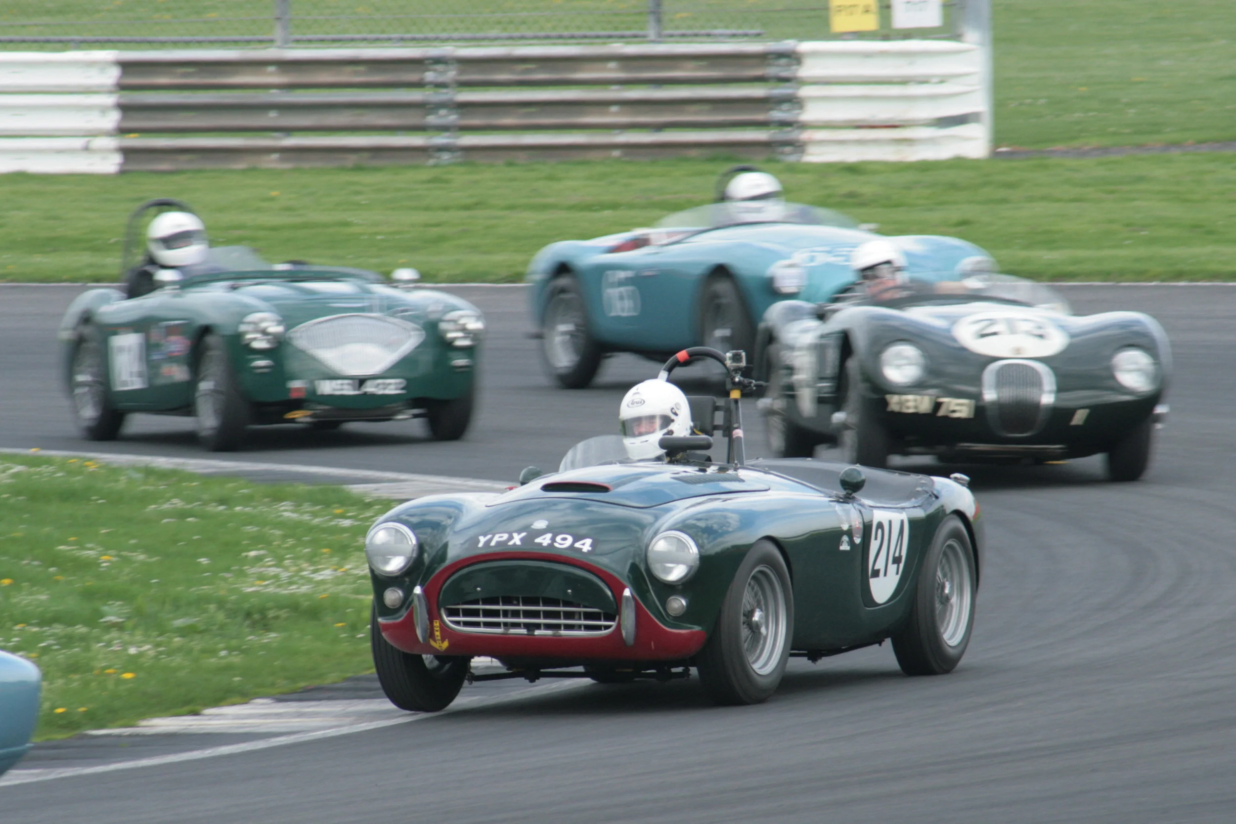 Tim Pearce drove his AC Ace superbly to finish 7th just behind the Lotus Elite of Brian Arculus. Here, David Brazell (Jaguar C Type) Jim Campbell (Austin Healey 100/4 and David Cottingham (AC Ace) give chase. Photo - John Turner