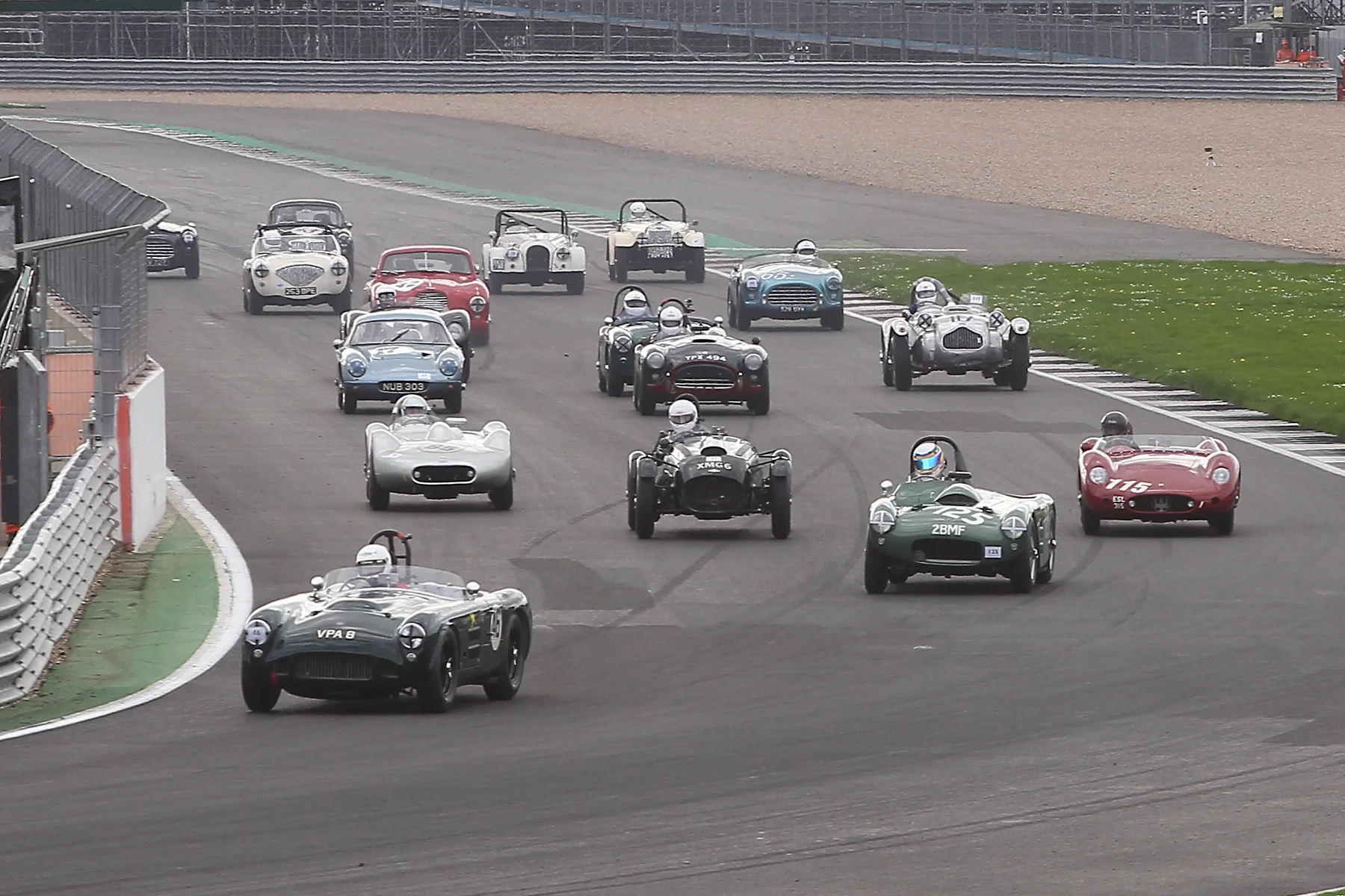 Great start by Martin Hunt took his HWM into the lead, whilst poleman, Richard Wilson, in his Maserati 250S has made a poor one and dropped to 3rd behind Richard Woolmer in the HWM Cadillac. Level with the Maserati is Martyn Corfield in the Frazer Nash LMR who has beaten Stephen Bond to the punch off the line. Please note the two white Morgans towards the back. Both Plus 4 models, Mark Shears Flat rad car is from 1952 whereas Alan House's is from 1959. Photo - Mick Walker 