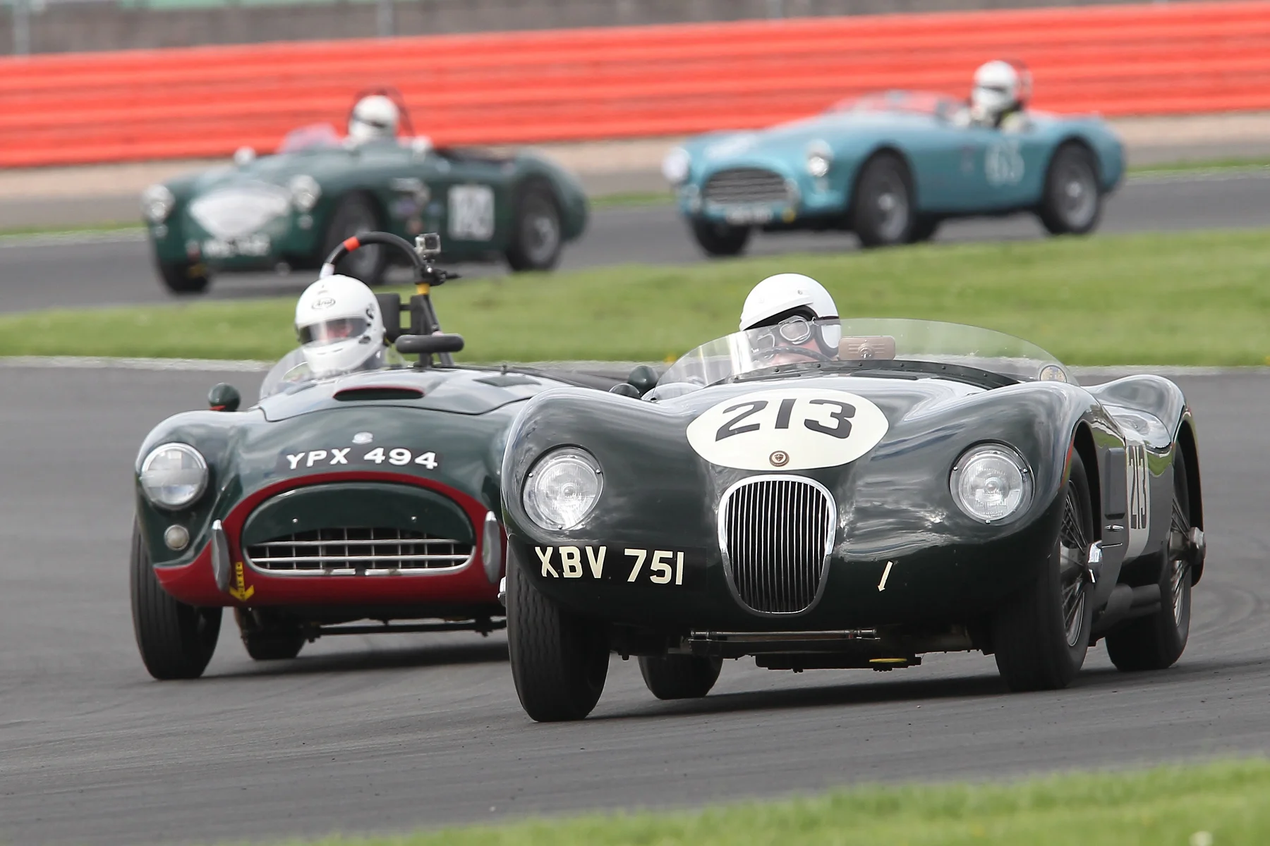 Tim Pearce (AC Ace) latches onto the tail of David Brazell's C-type Jaguar. In the background, Jim Campbell (Austin Healey 100/4) holds off David Cottingham's AC Ace. Between the two pairing out of sight and to the left is the Allard J2. Photo - Mick Walker 