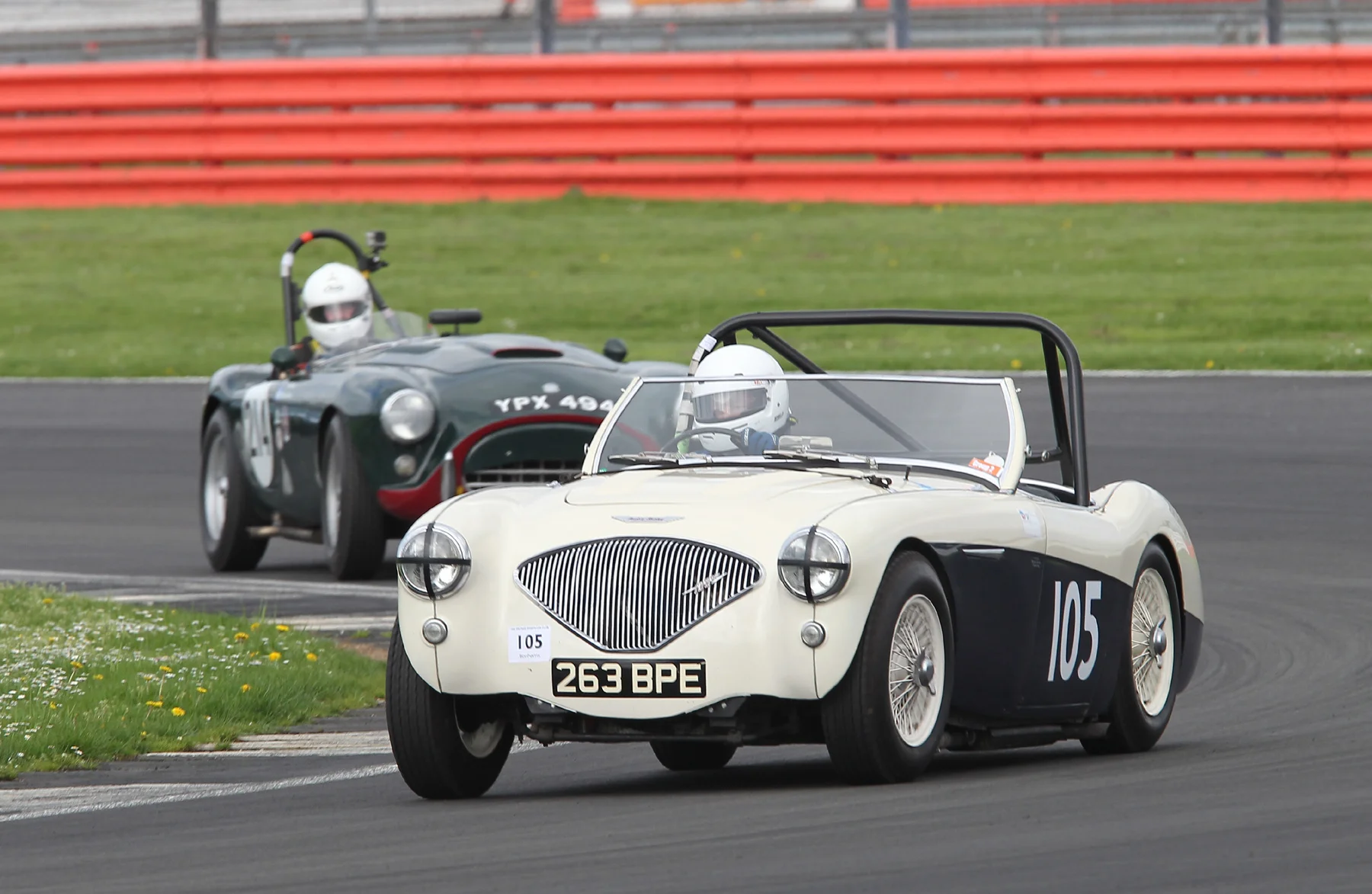 Matthew Collings presses on in his very standard Austin Healey 100M but is about to be lapped by Tim Pearce inn his AC Ace Bristol Photo - Mick Walker