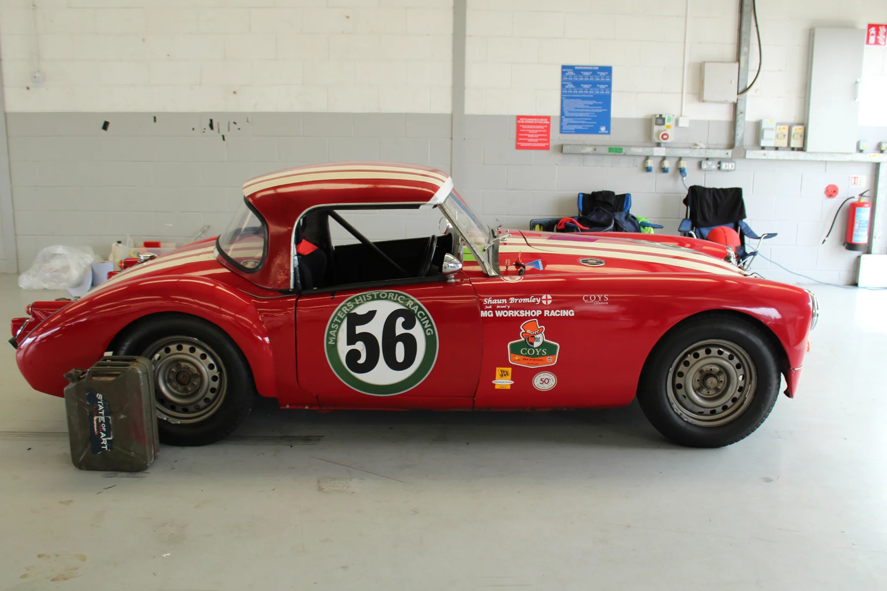 Shaun Bromley’s MGA Coupe in one of the Pit garages. An element of humour displayed on the Jerry Can! Photo - John Turner