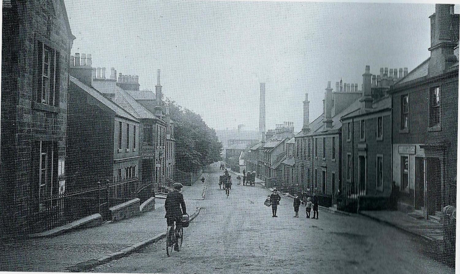 Dalry Ayrshire, New Street, the principle street, begins at Biggart's Mill, seen in the distance and ends at the Cross.