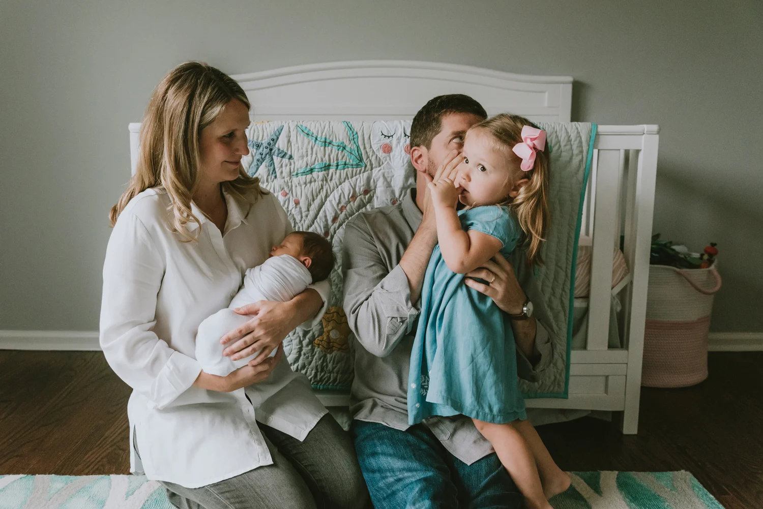 Daddy whispering to big sister during newborn photography session in Essex County New Jersey. New Jersey Newborn Photographer.