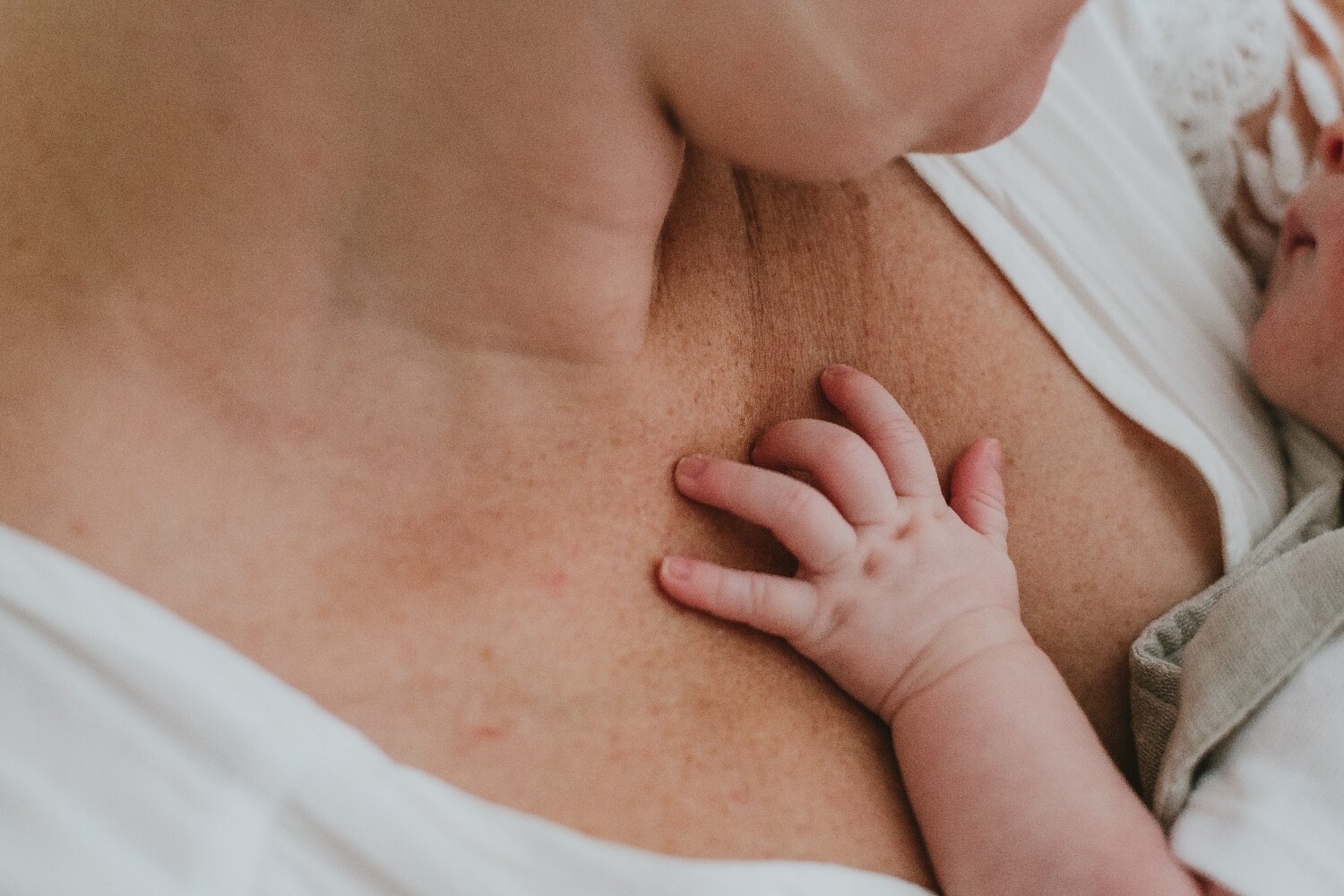 Image-Of-Newborn-Hand-On-Mother's-Chest