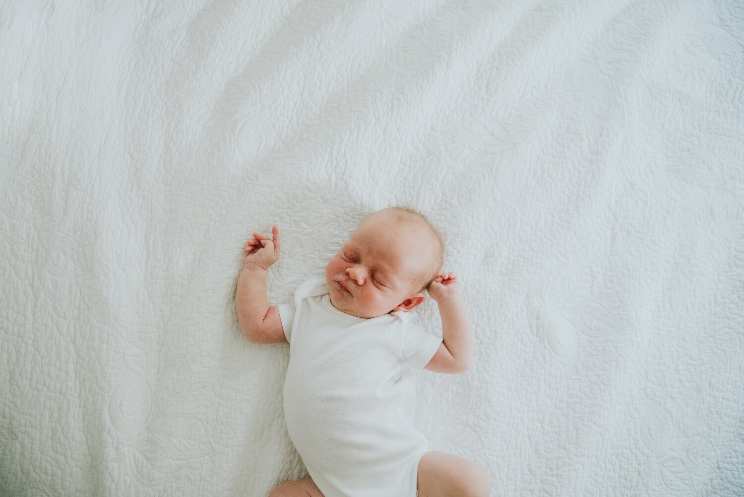 Image-Of-Newborn-Stretching-In-Parents-Bed