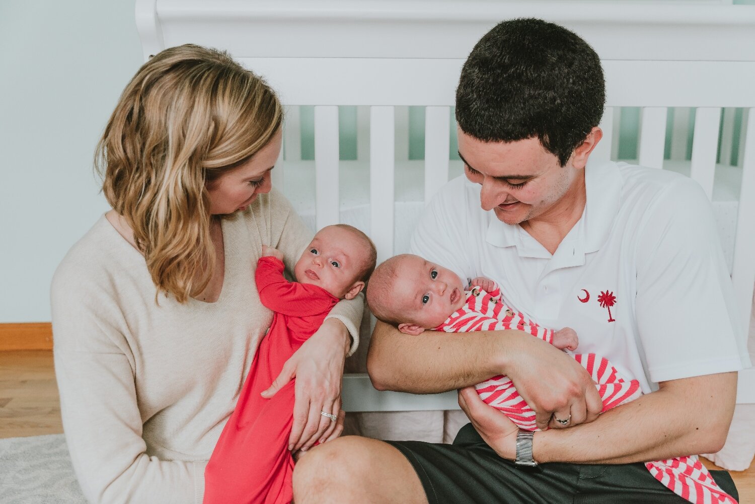 Photo-Of-Parents-In-Nursery-Snuggling-Newborn-Twin-Babies