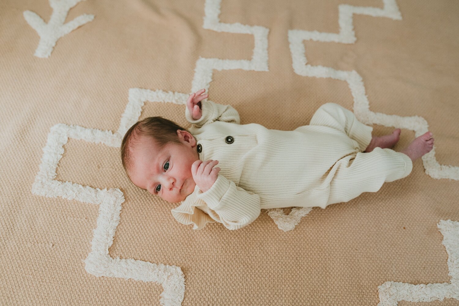 Newborn-Baby-Girl-On-Carpet-In-Her-Nursery