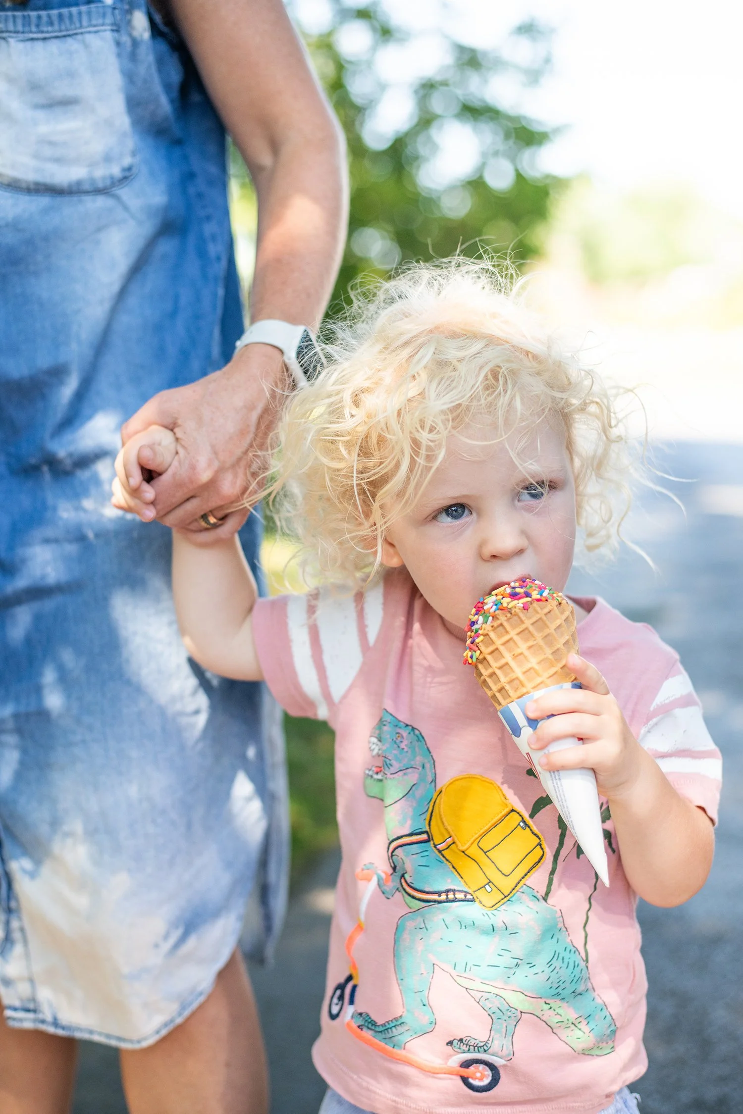 Little Boy Taking A Bite Out Of Ice Cream Cone with Sprinkles